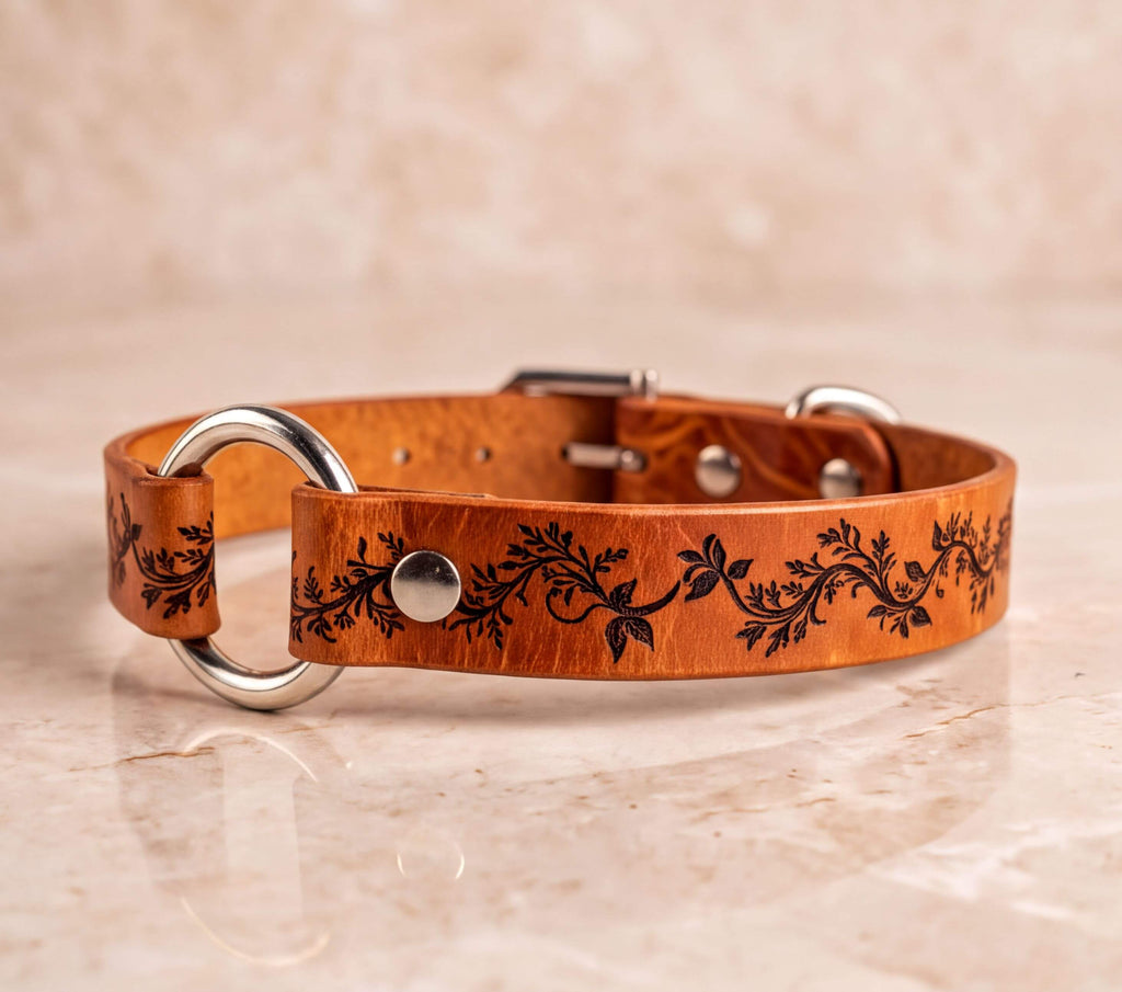 A brown leather dog collar with a floral design on it.