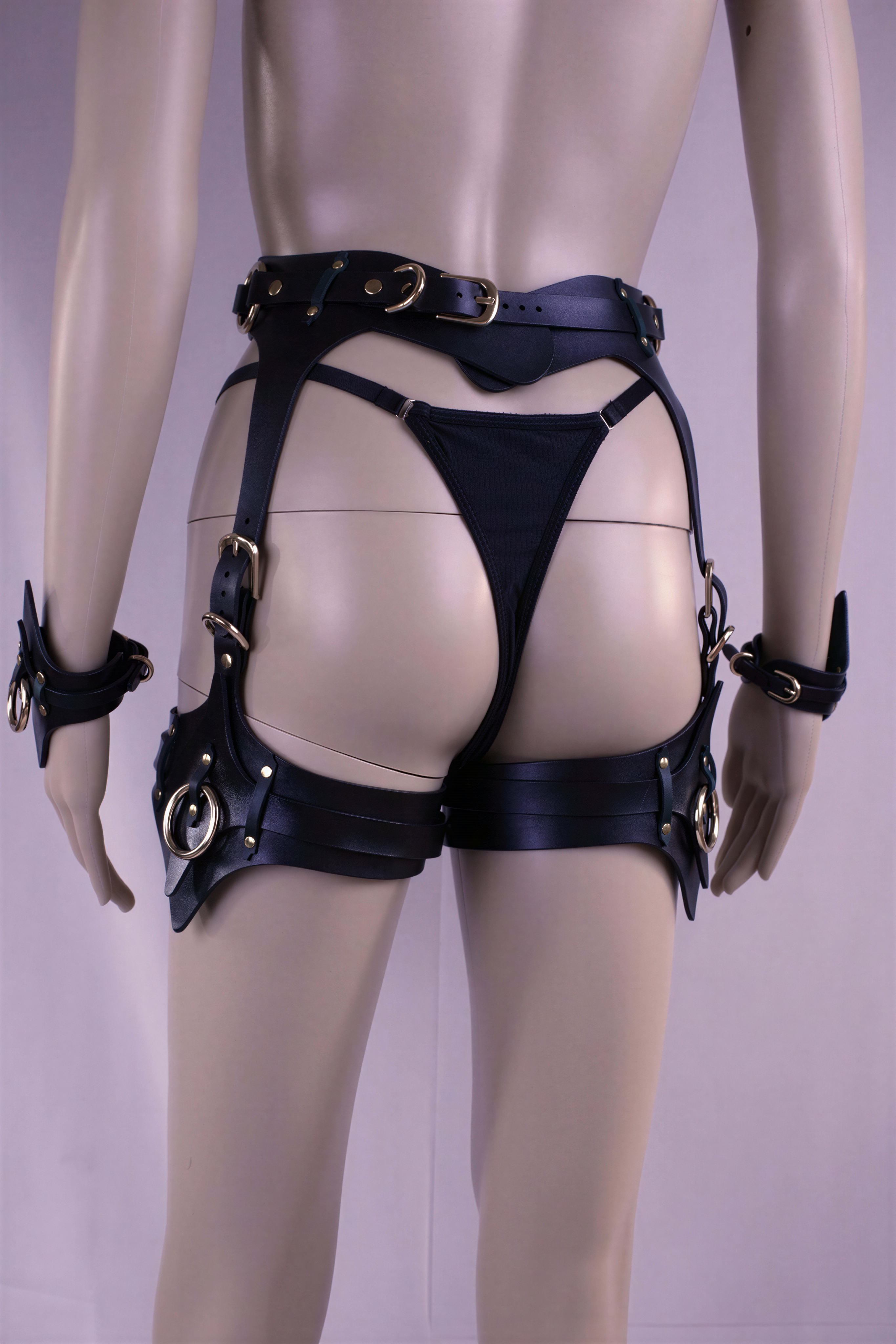 Thigh harness and cuffs set made from Italian leather for bondage and BDSM play, featuring adjustable straps and stylish design.