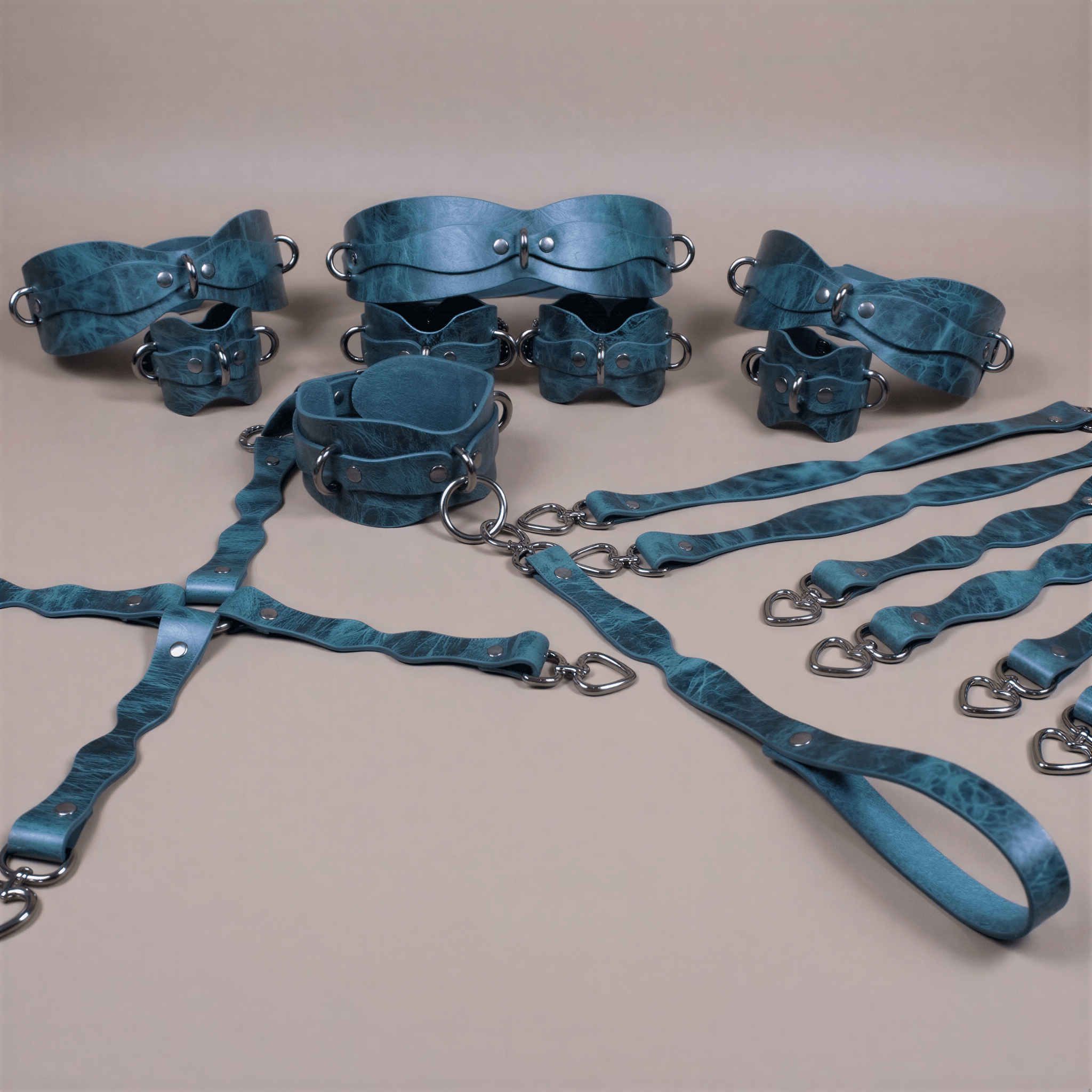 A collection of various leather straps and buckles in shades of blue and green, arranged on a beige background.
