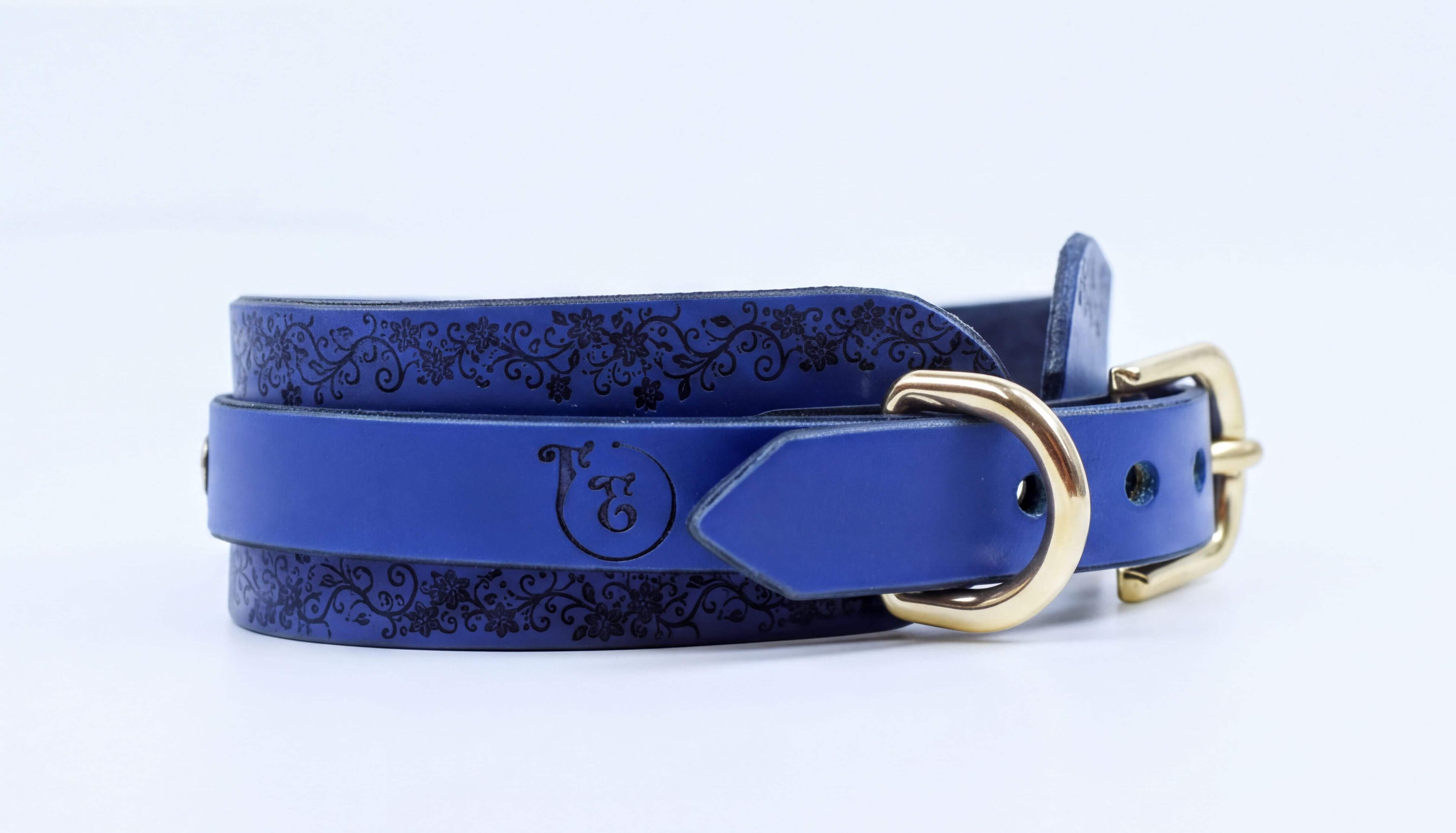 A blue leather belt with a gold buckle, featuring a decorative pattern on the surface.