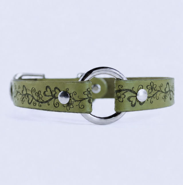 A green leather collar with a floral design and metal ring.