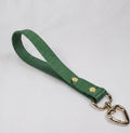 A green leather strap with a heart-shaped metal clasp attached to it.