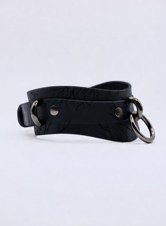 A black leather choker necklace with metal rings and a metal clasp.