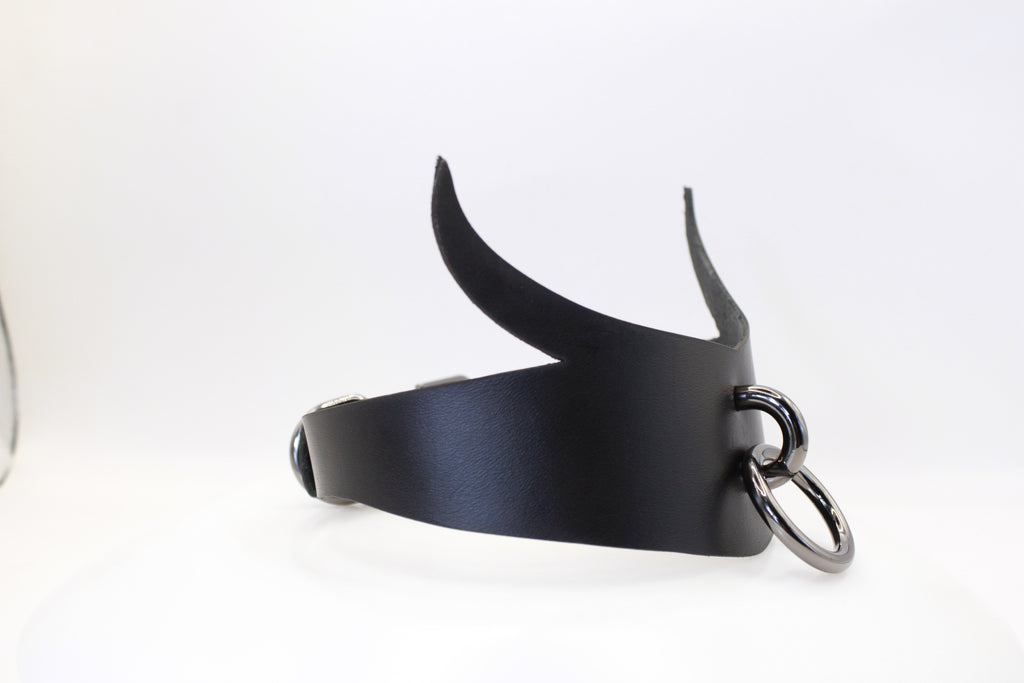 A black leather choker necklace with a metal ring and two curved horns.