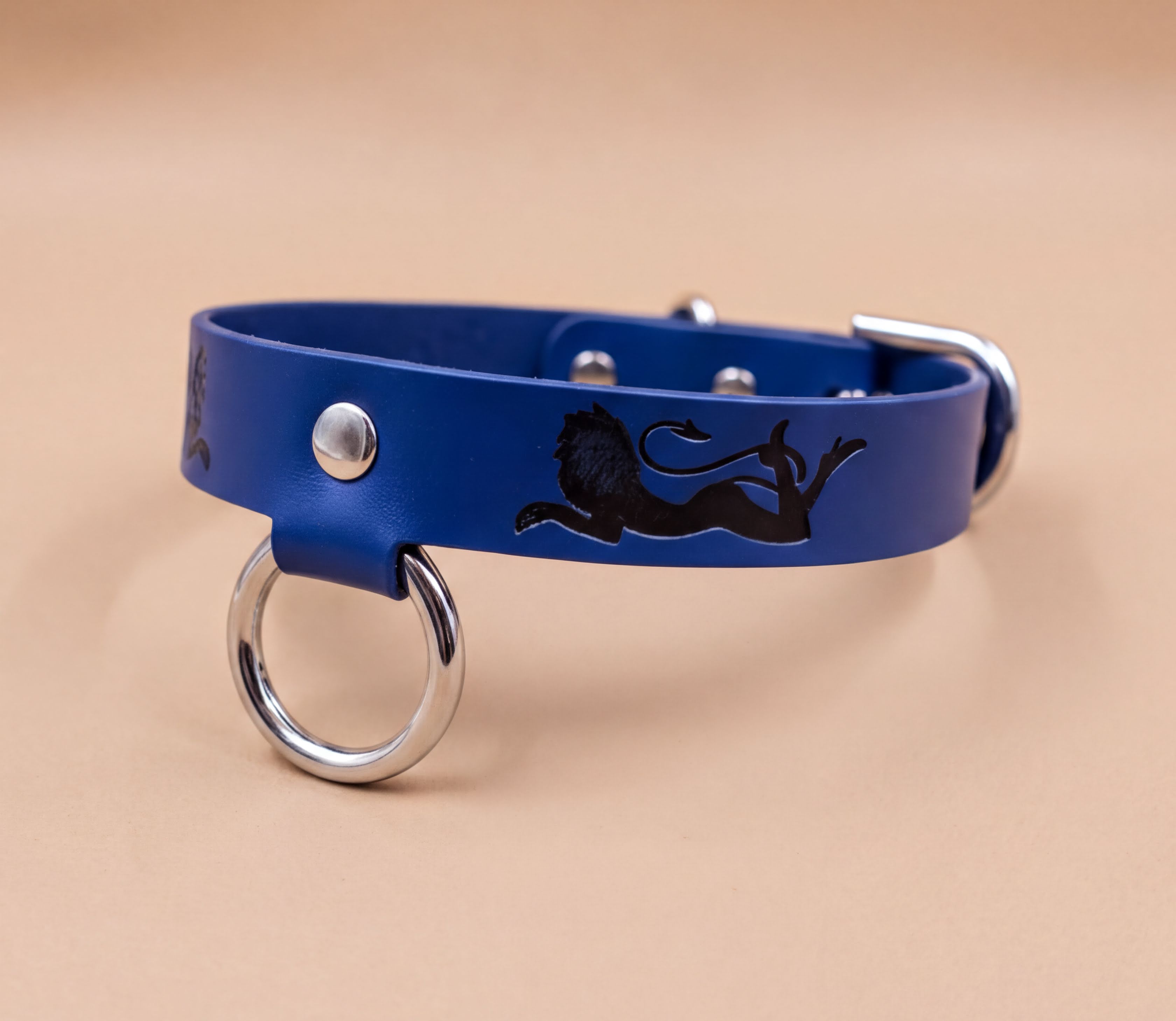 A blue leather collar with a lion design and metal rings on the front.