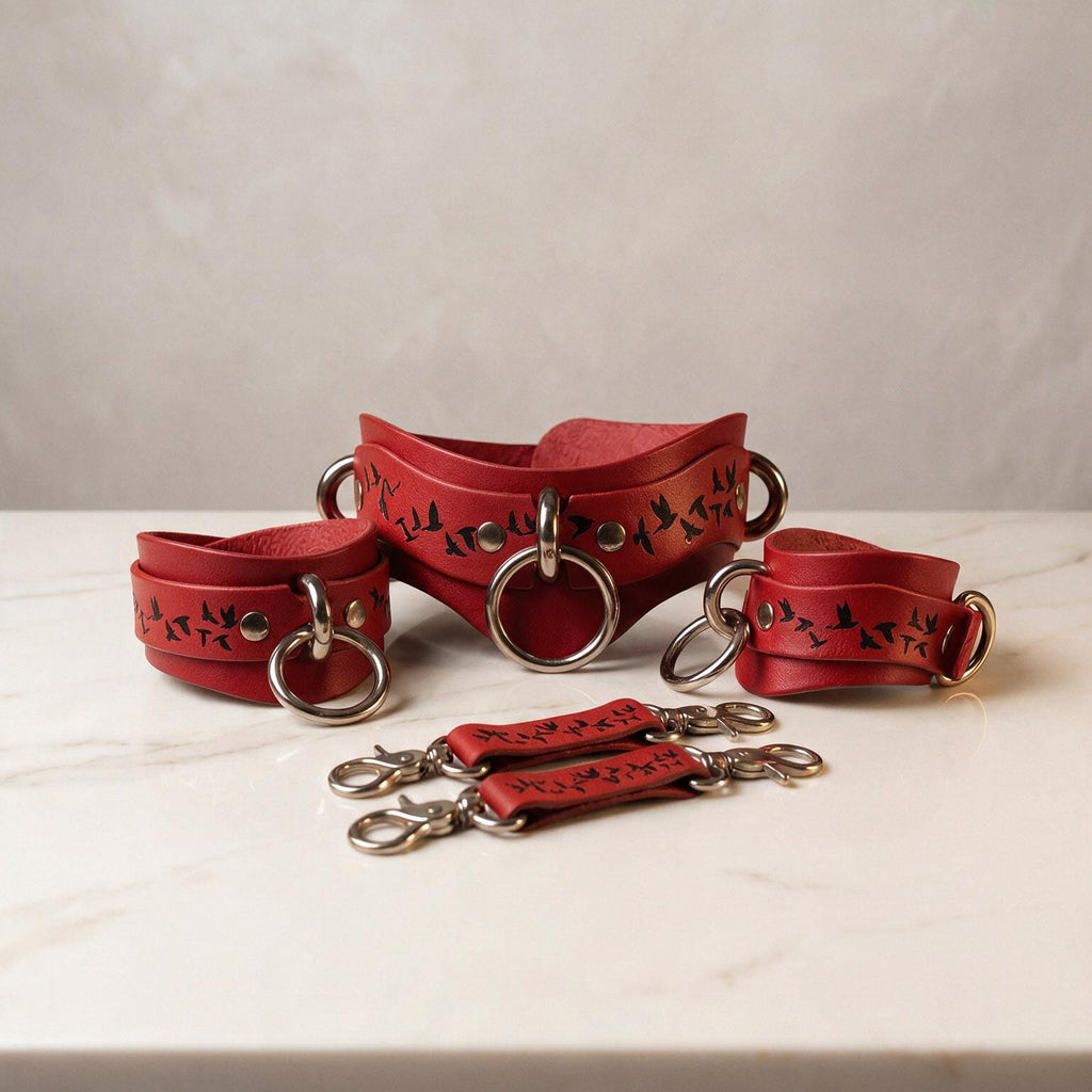 a collection of red leather straps with metal rings and buckles, arranged on a white marble surface.