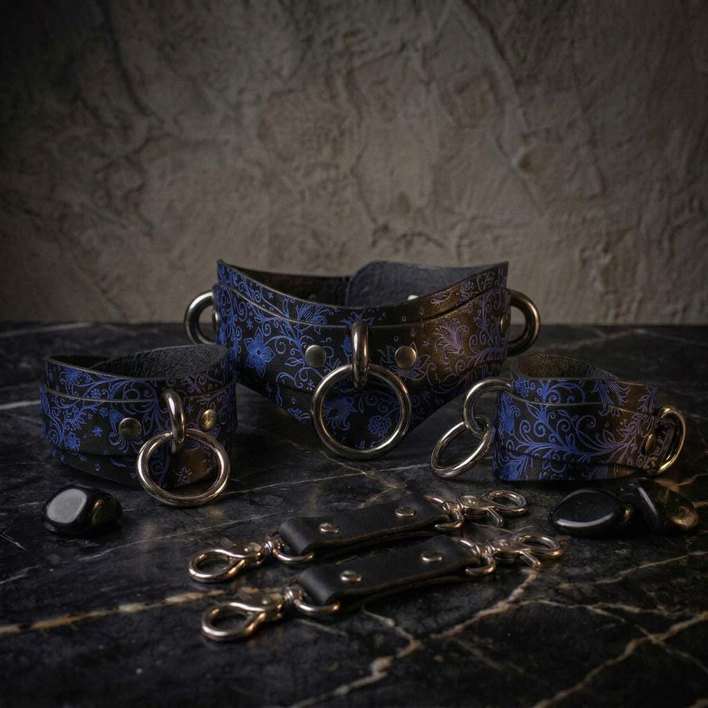 A set of ornate leather straps with metal rings and buckles, arranged on a dark surface.