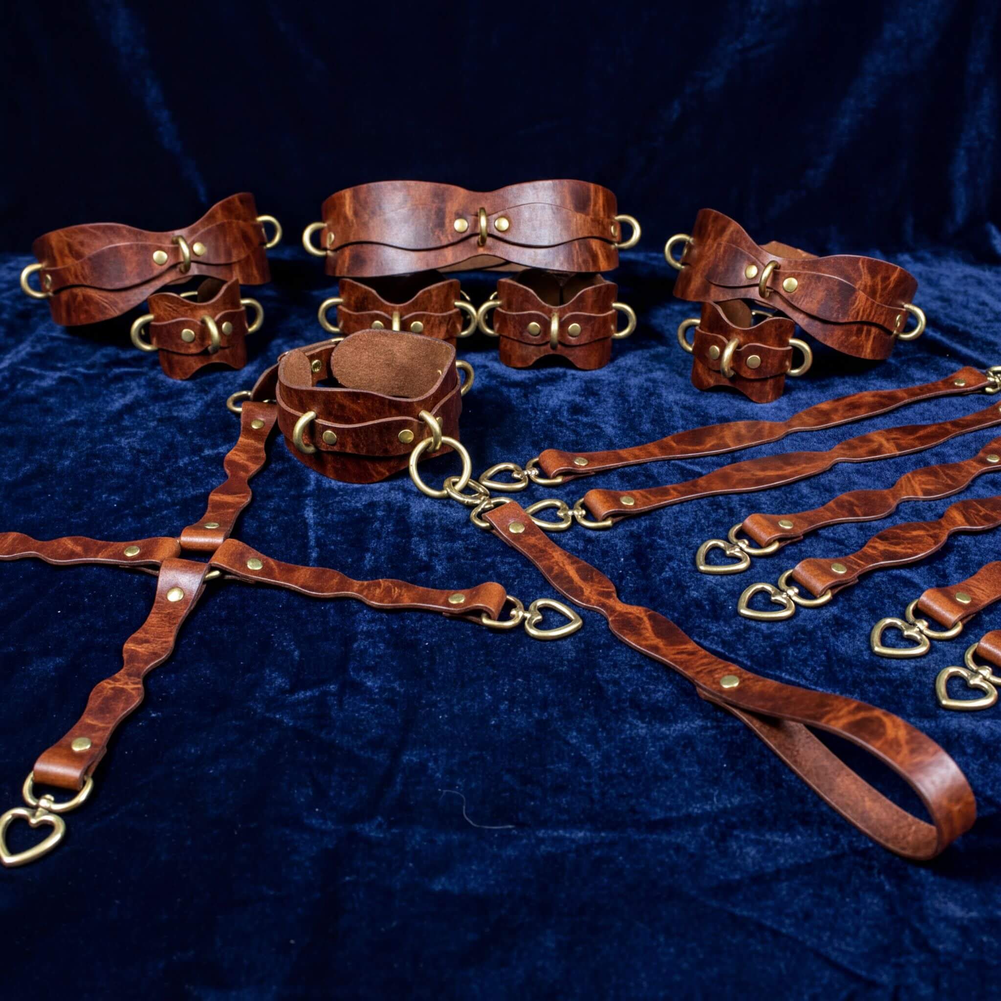 a collection of brown leather straps and buckles arranged on a blue velvet background.