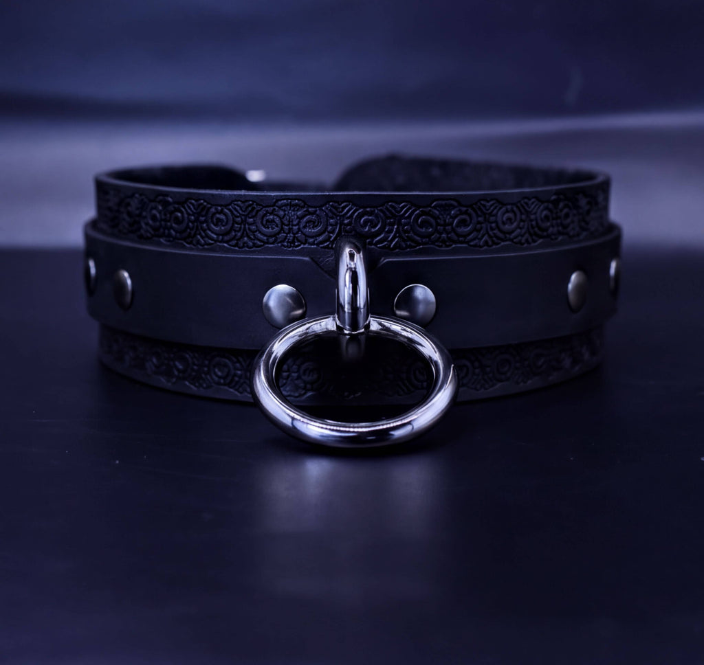 A black leather choker necklace with a silver ring and buckle.