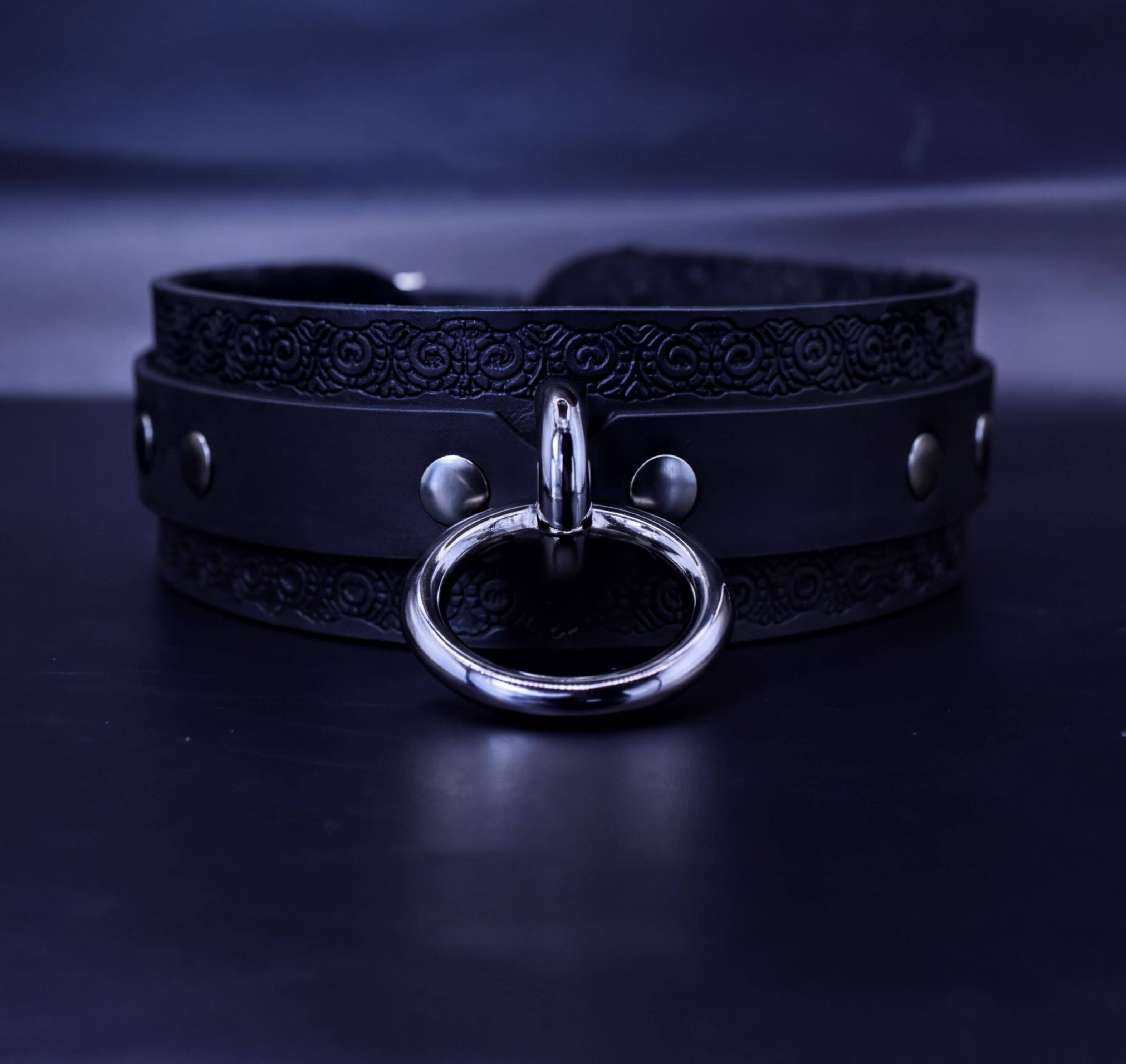 A black leather choker necklace with a silver ring and buckle.