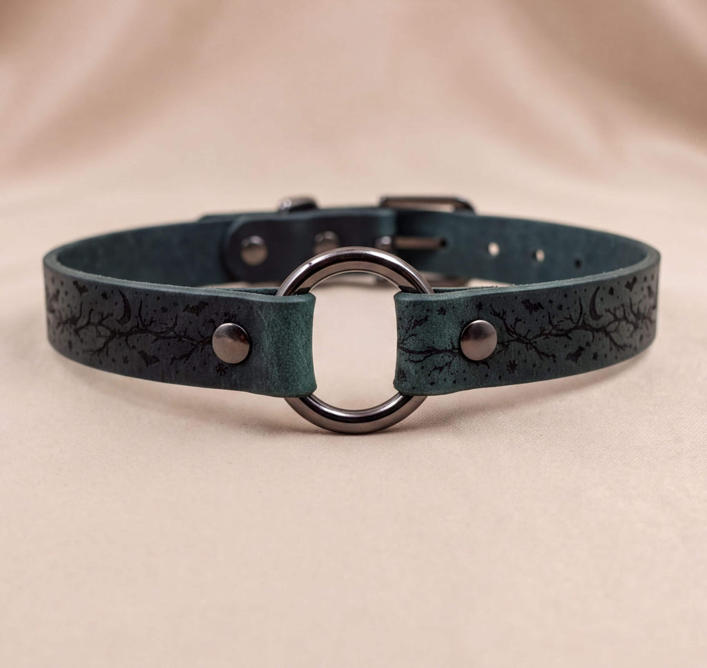 A dark green leather choker collar with a metal ring and two metal buttons.