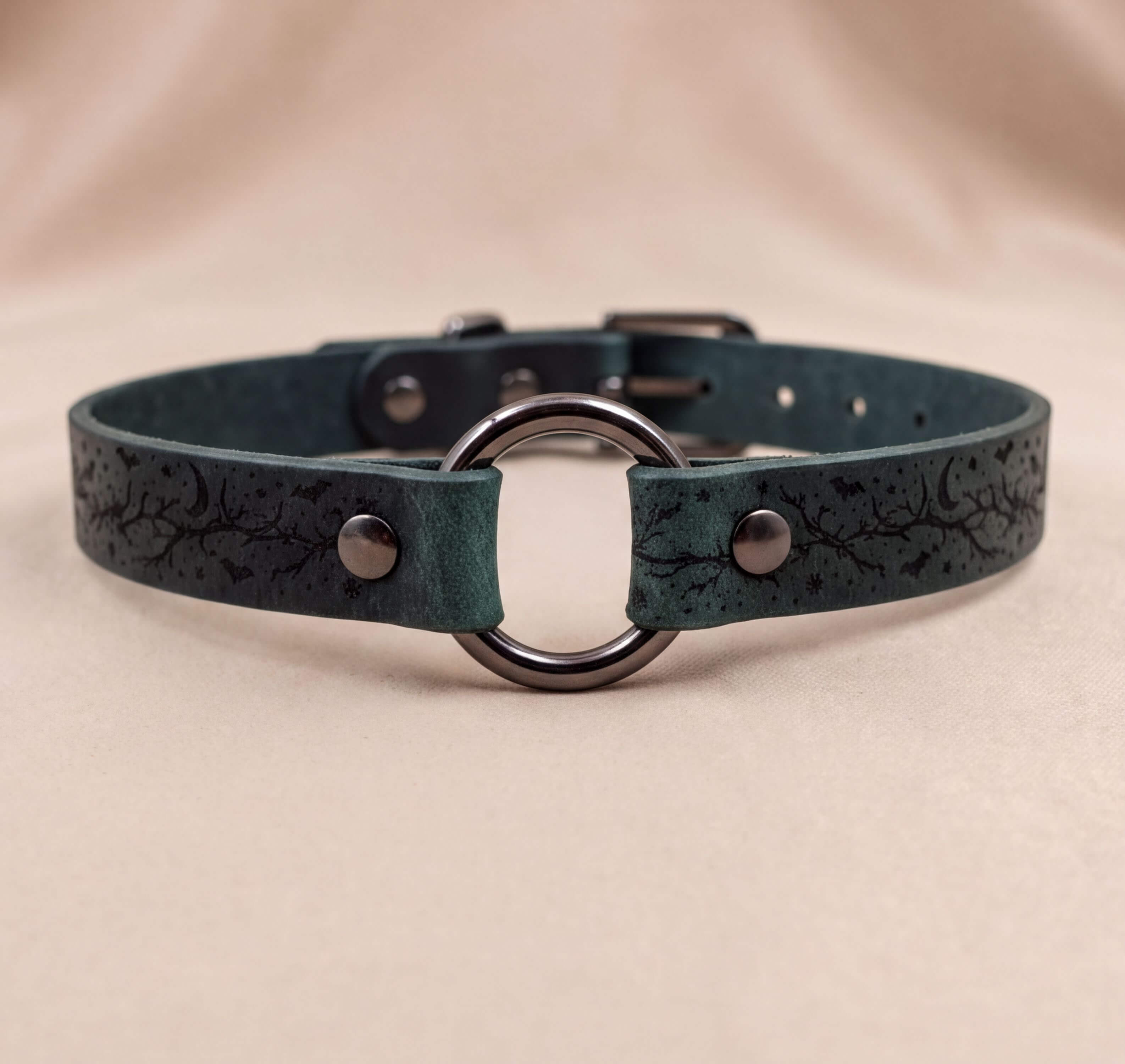 A dark green leather choker collar with a metal ring and two metal buttons.