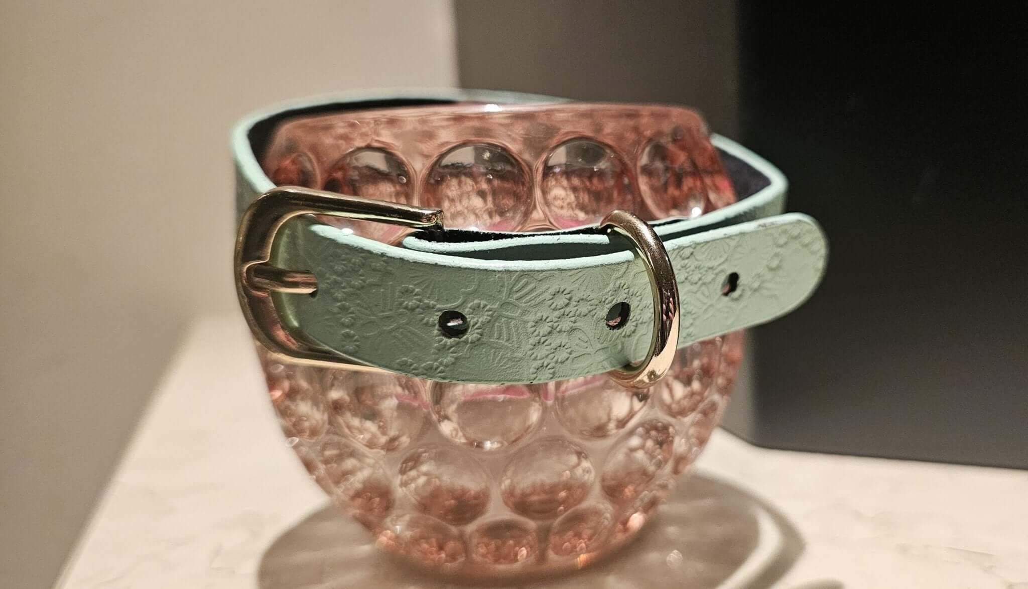 Elegant mint green floral leather choker collar resting on a decorative glass bowl, perfect for BDSM and DDLG aesthetics.
