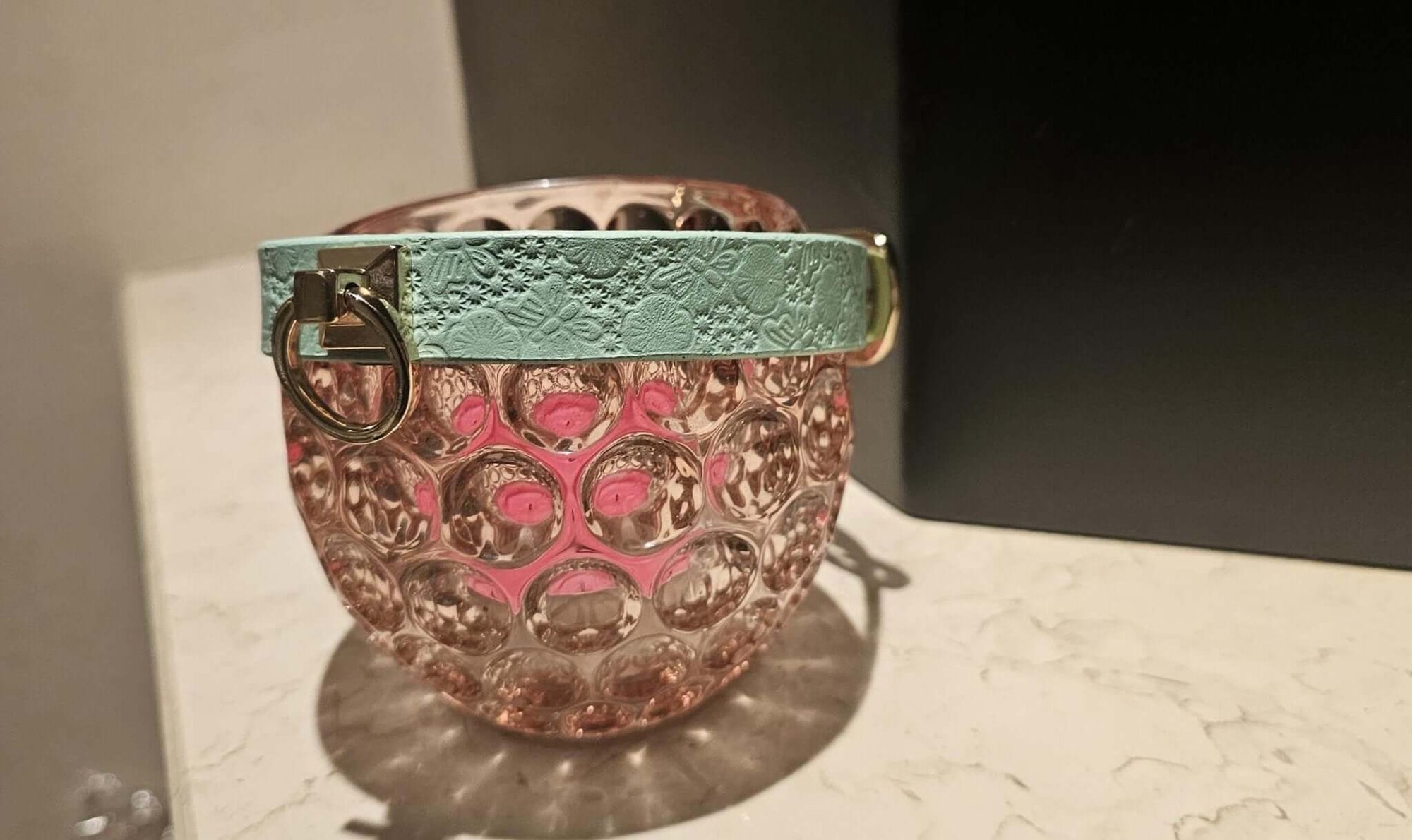 Elegant pastel floral leather collar on a decorative glass, perfect for BDSM, DDLG, and alternative fashion.