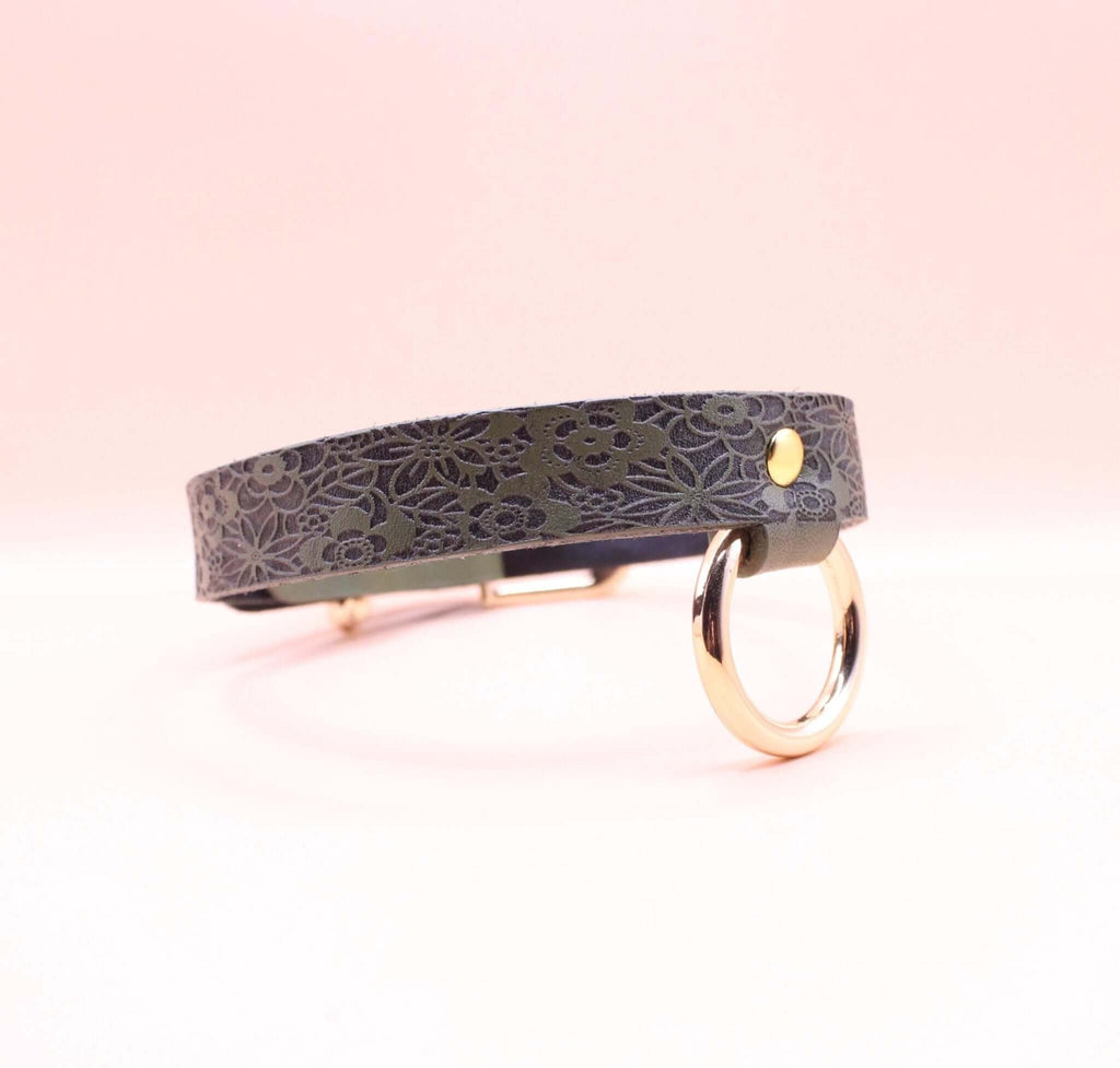 Elegant discreet day collar in premium leather, featuring floral design and metal ring, perfect submissive jewelry accessory.