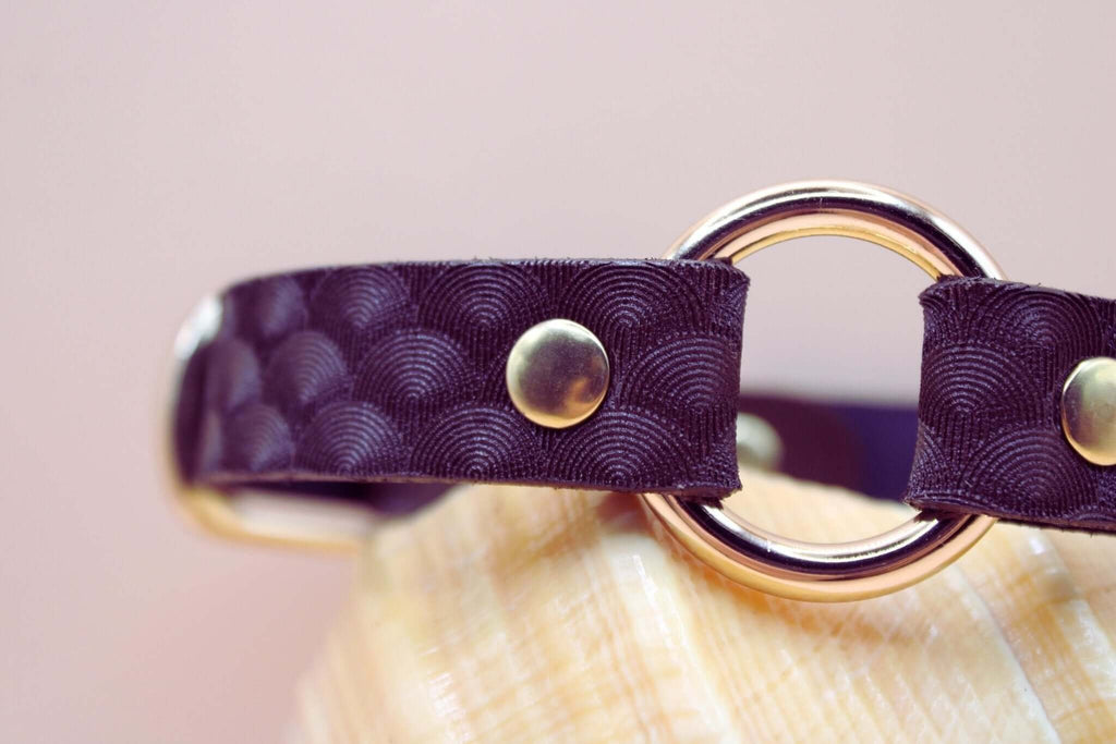 Elegant purple leather choker with scallop texture and gold hardware, perfect for BDSM and submissive jewelry.