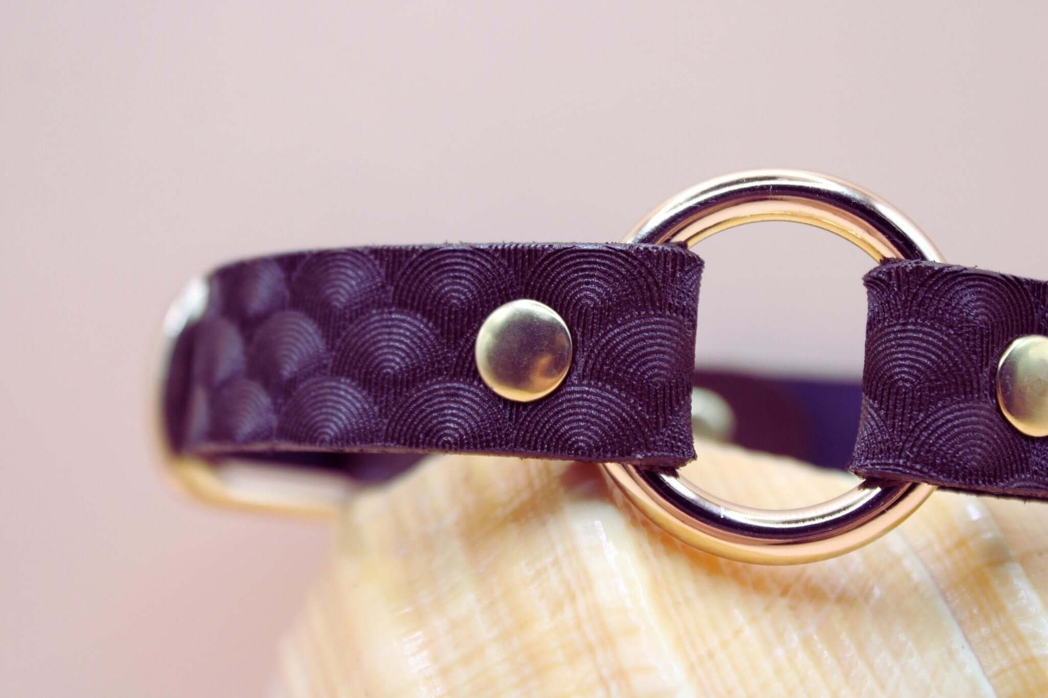 Elegant purple leather choker with scallop texture and gold hardware, perfect for BDSM and submissive jewelry.