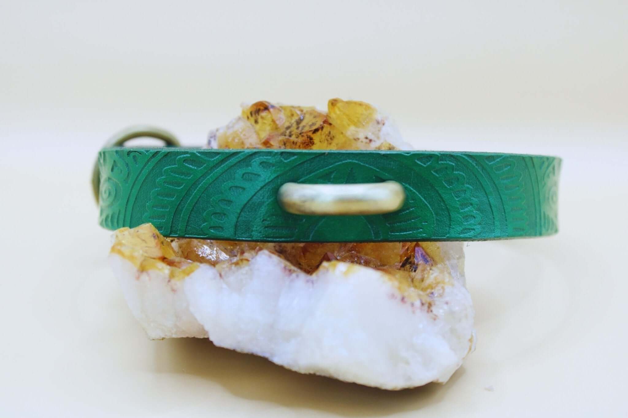Emerald green leather submissive collar on a crystal, ideal for BDSM, bondage gear, and dom/sub lifestyle.