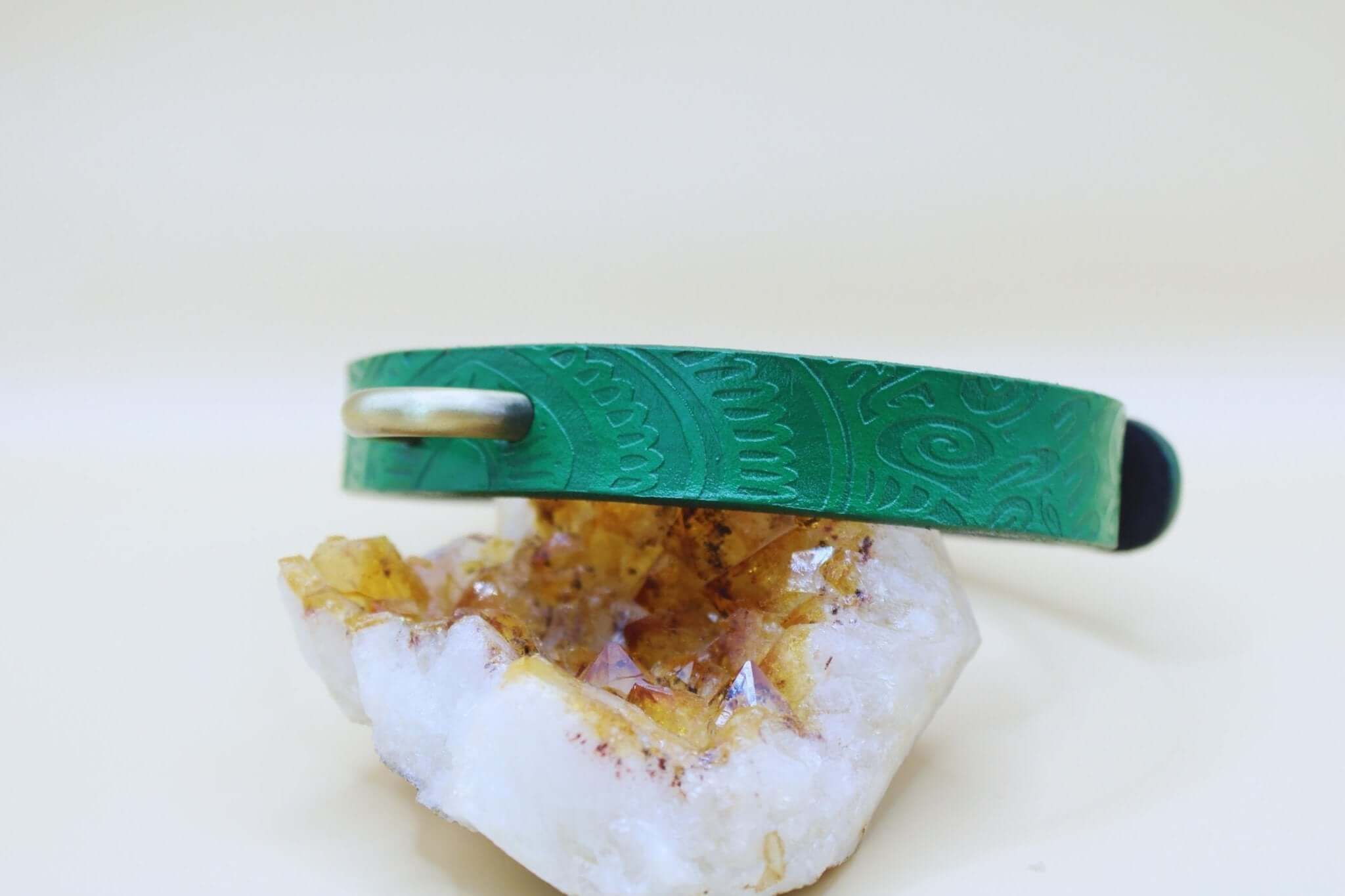 Emerald green handcrafted leather choker collar for submissive petplay, featuring embossed designs on a crystal base.