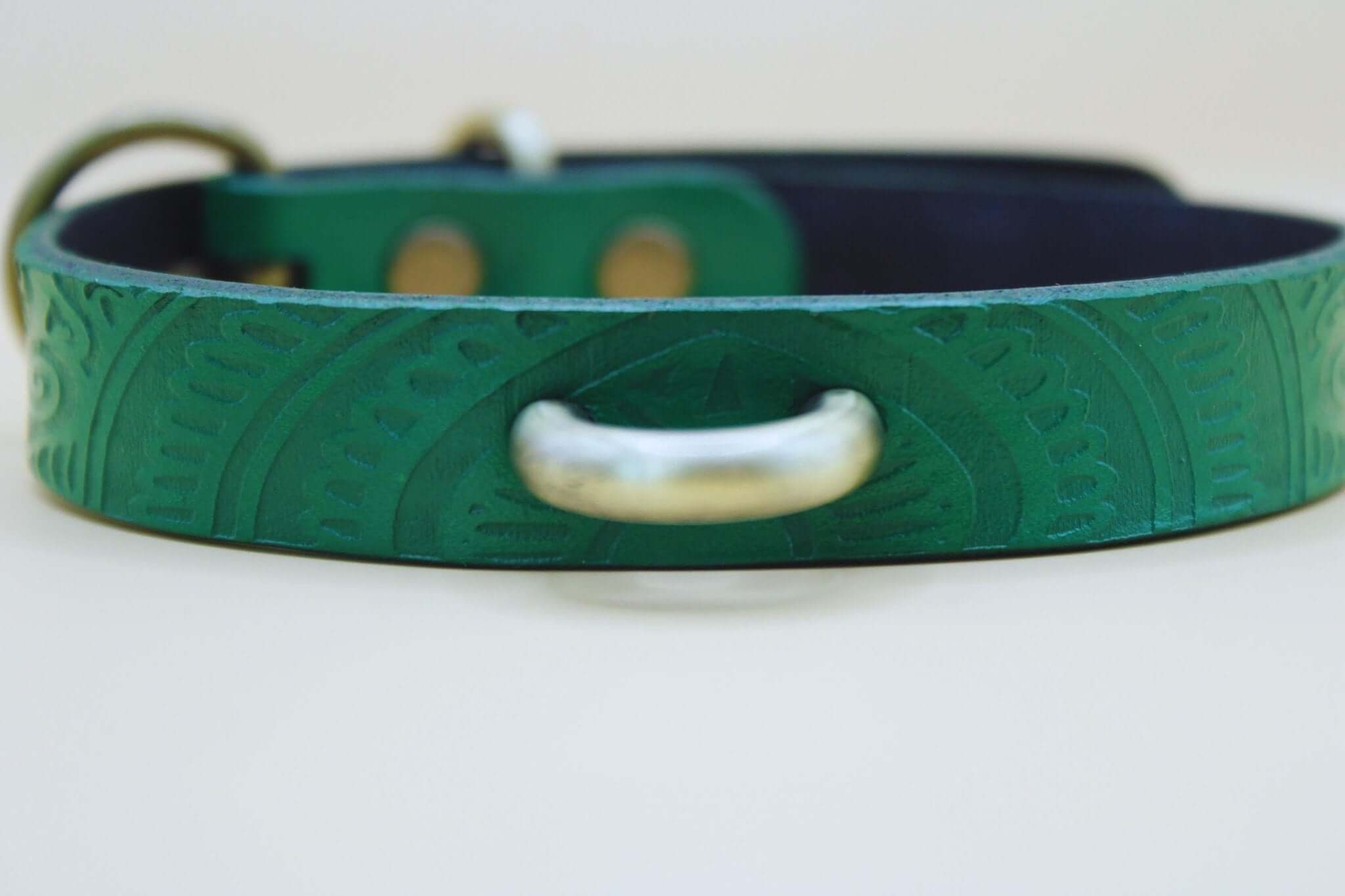Emerald green handcrafted leather submissive collar for BDSM and petplay, featuring intricate designs and a sturdy metal ring.