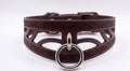 A brown leather choker collar with a metal ring and buckle.