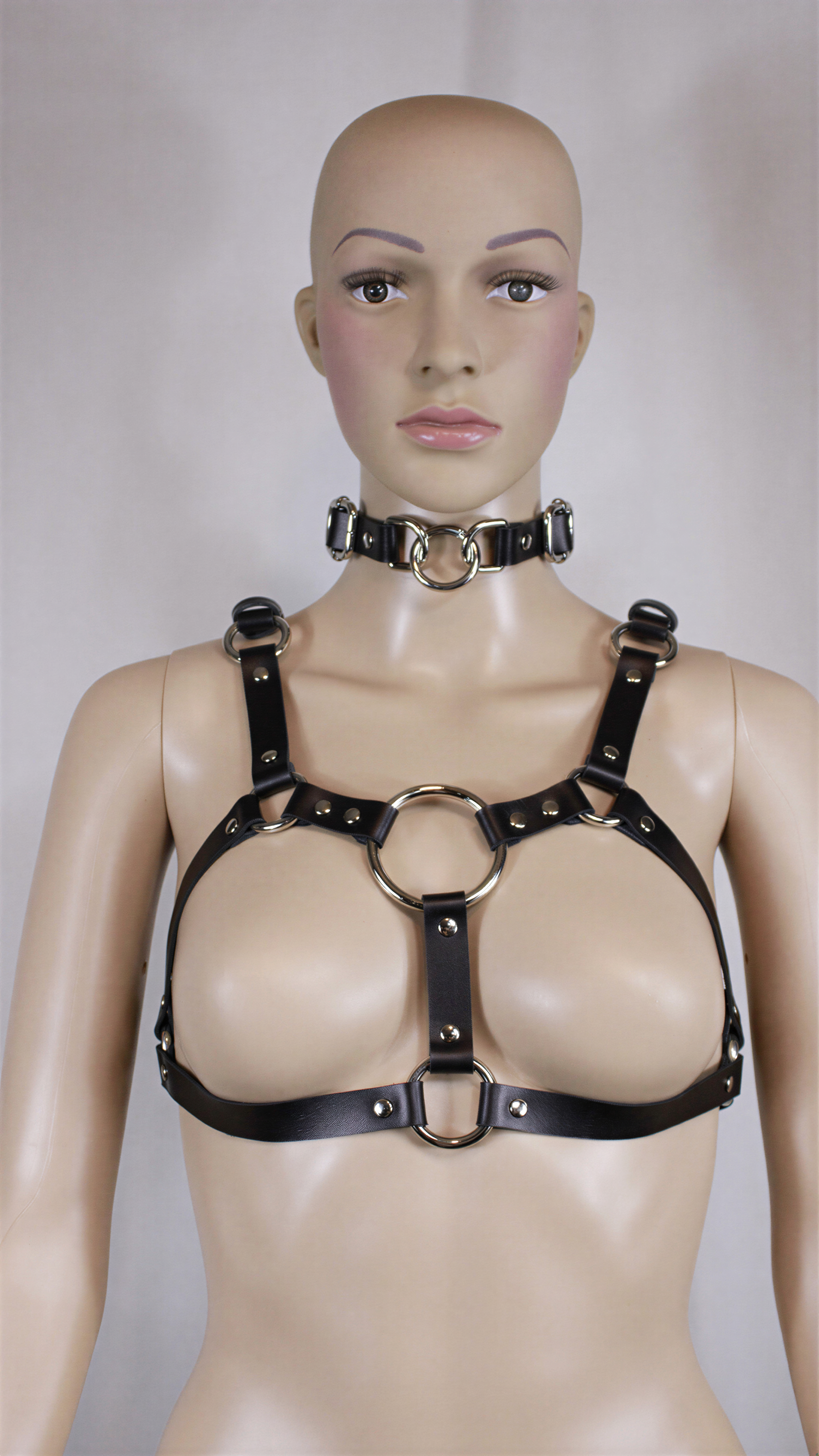 Italian leather BDSM bra harness displayed on a mannequin, featuring a matching collar and metallic hardware accents.