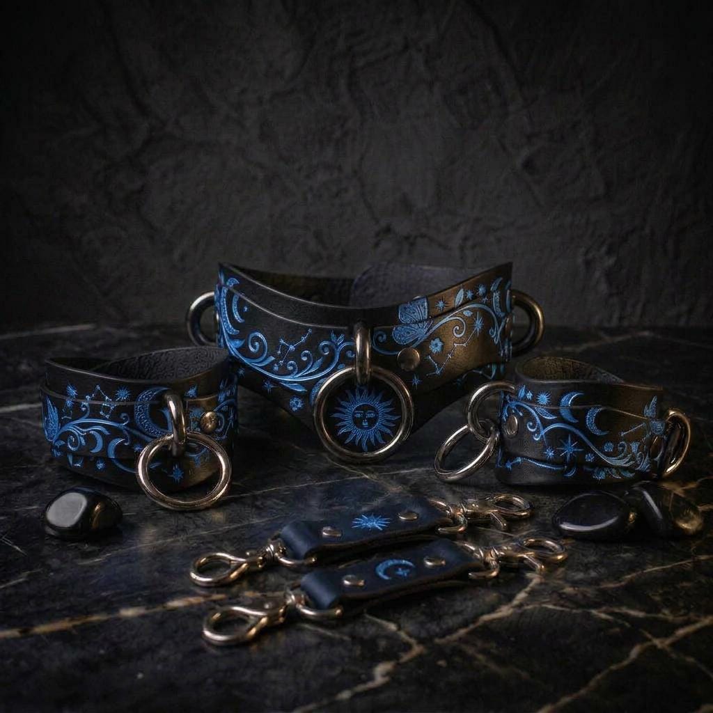 A collection of ornate leather choker necklaces and straps with intricate blue designs, including sun and moon motifs, against a dark background.