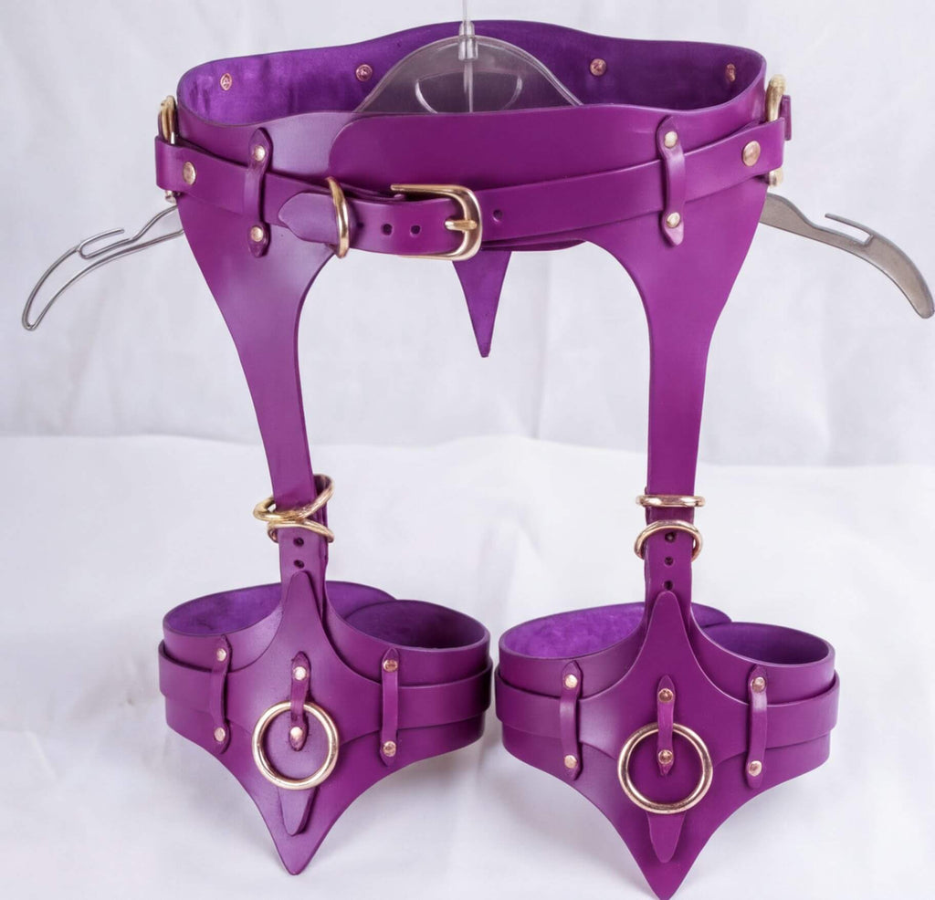 A pair of purple leather straps with gold hardware, including buckles and rings, attached to a belt.