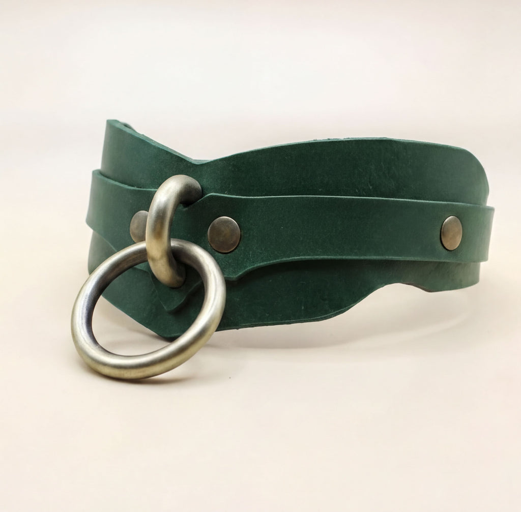 A green leather choker necklace with a metal ring and two metal fasteners.