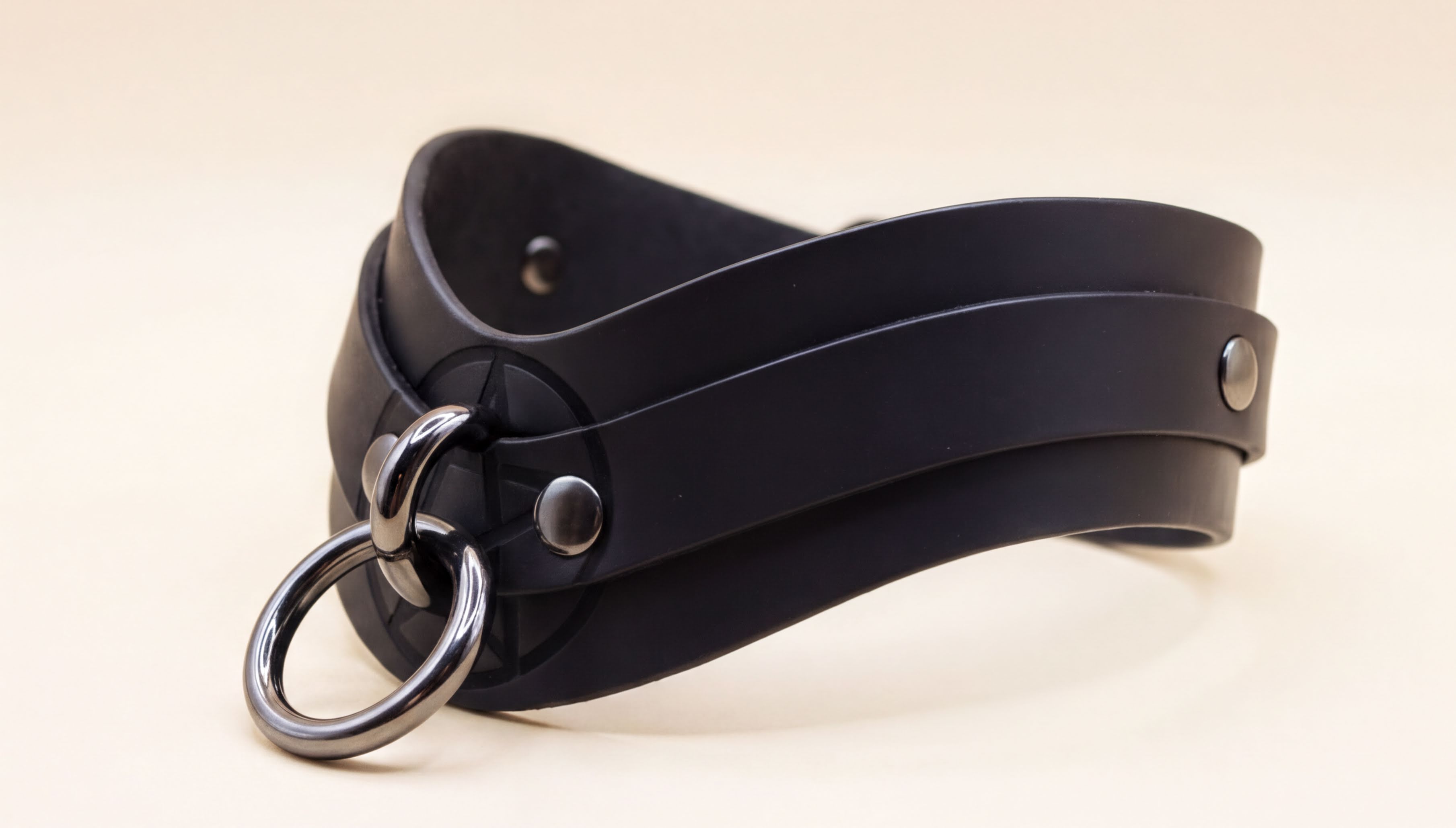 A black leather choker necklace with a metal ring and buckle.