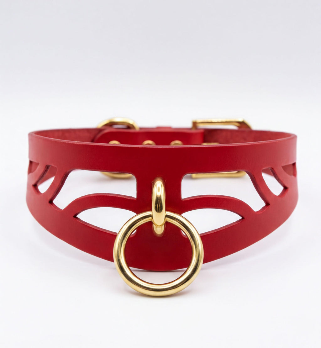 A red leather choker necklace with a gold-colored metal ring and buckle.