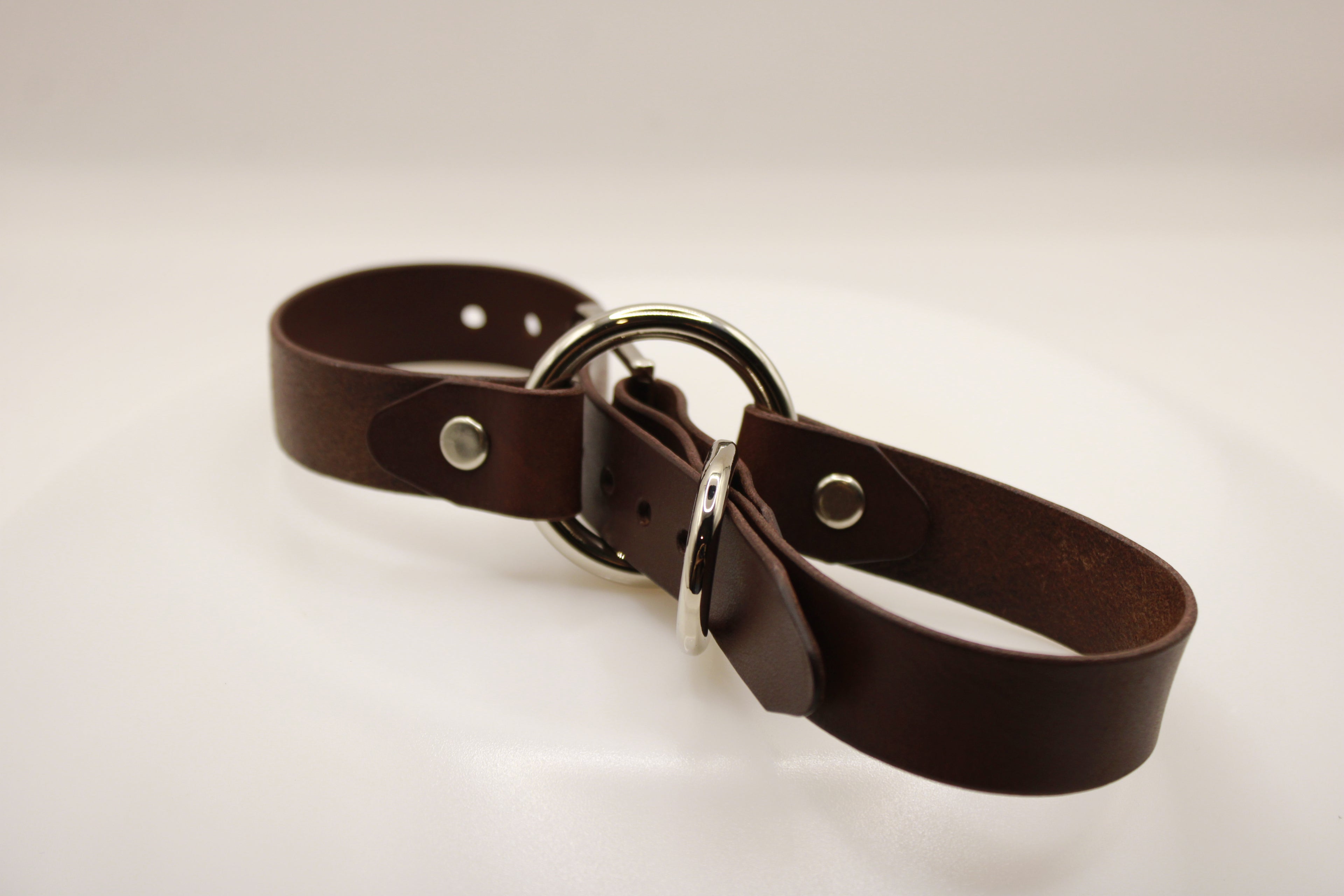 A brown leather belt with a silver buckle is shown in the image.