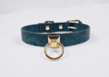 A teal-colored leather choker collar with a gold-colored metal ring and buckle.