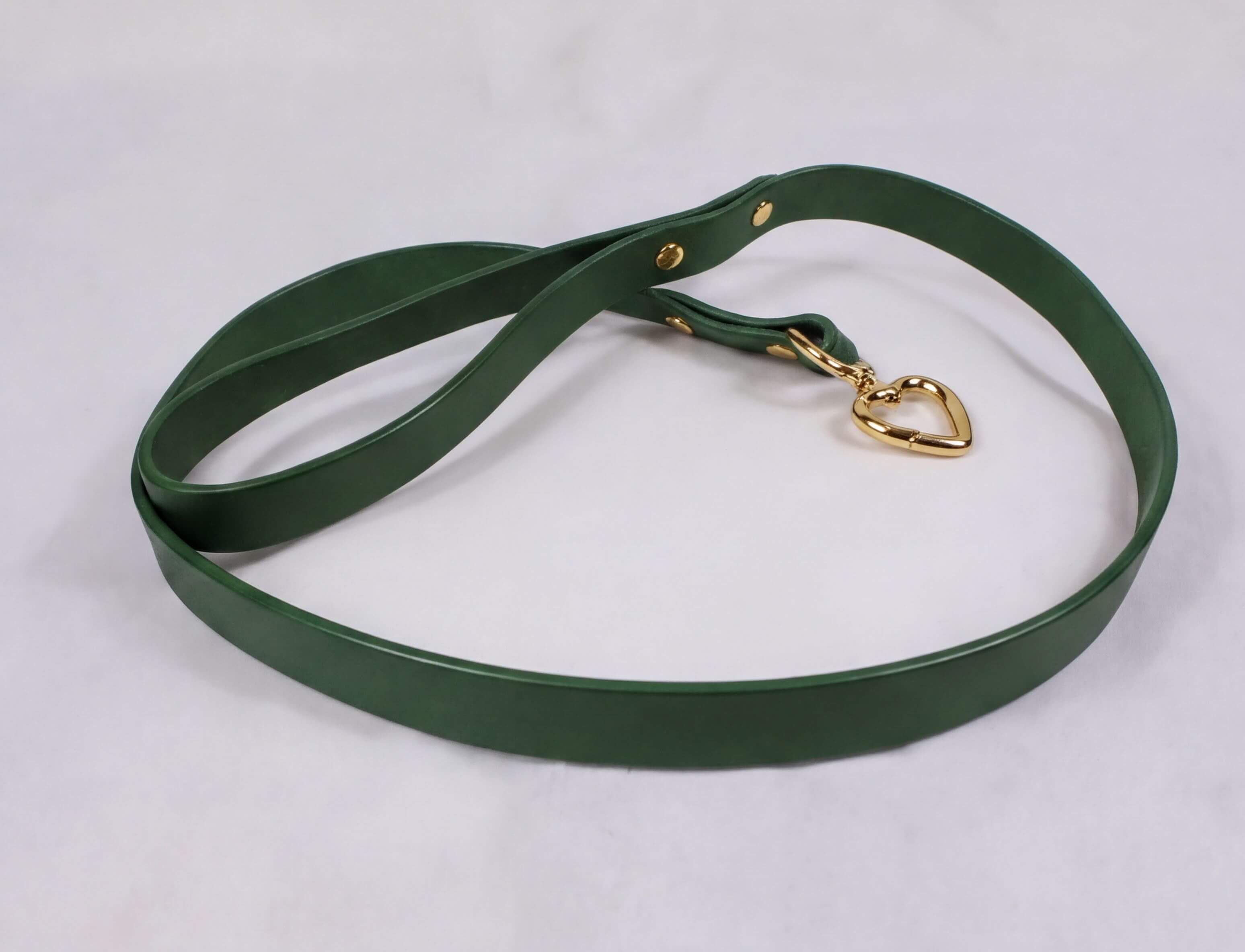 A green leather leash with a gold heart-shaped charm attached.