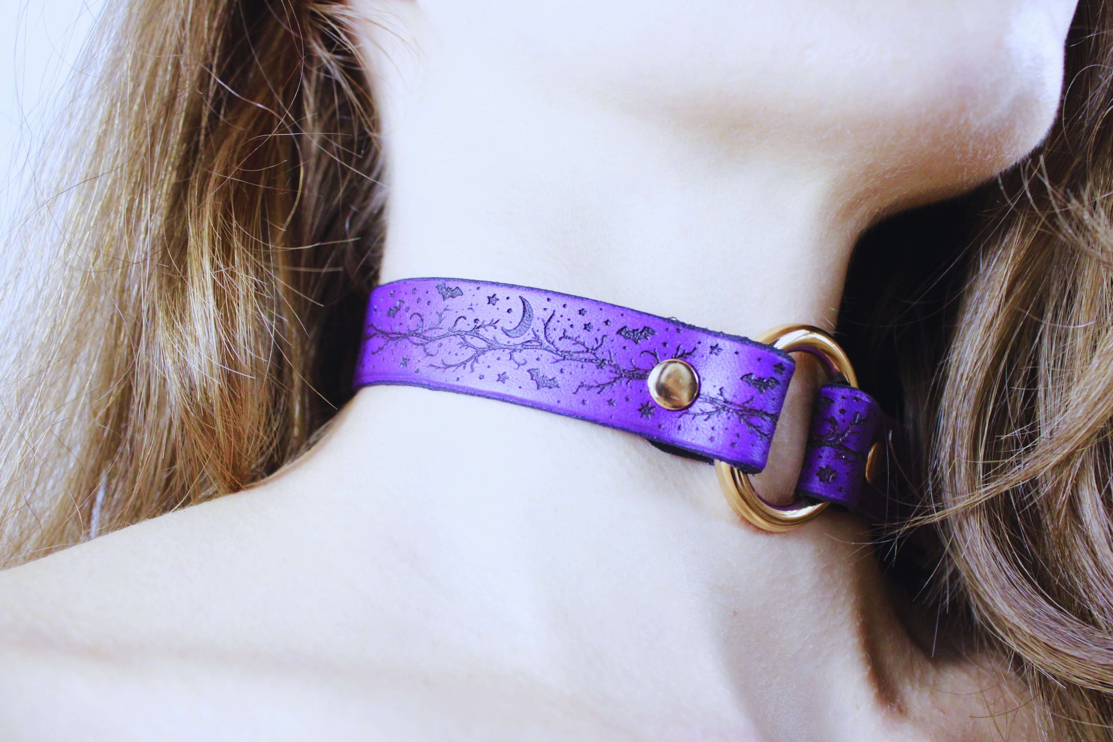 Bats Leather Choker on model, featuring a purple leather design with celestial patterns and a stylish gold ring.