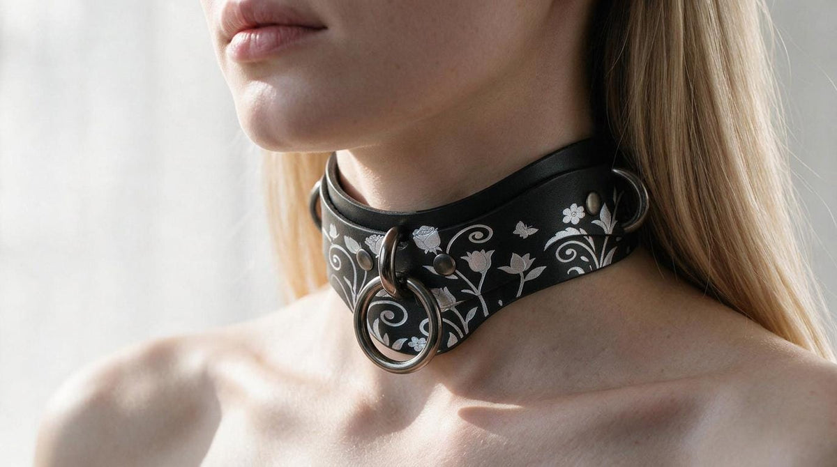 A close-up of a woman's neck and chest area wearing a black choker necklace with a floral design.