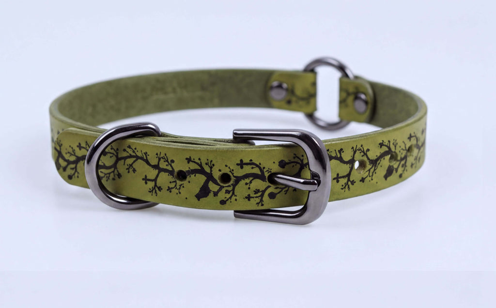 A green leather dog collar with a black tree branch design on it.