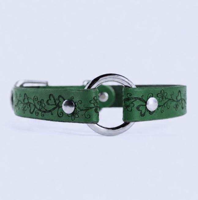 A green leather collar with a metal ring and decorative floral patterns.