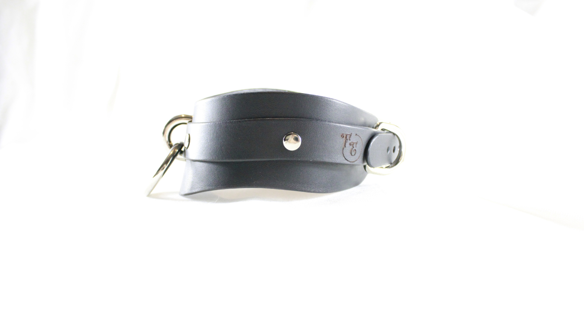 A black leather strap with a metal buckle and a small logo on it.