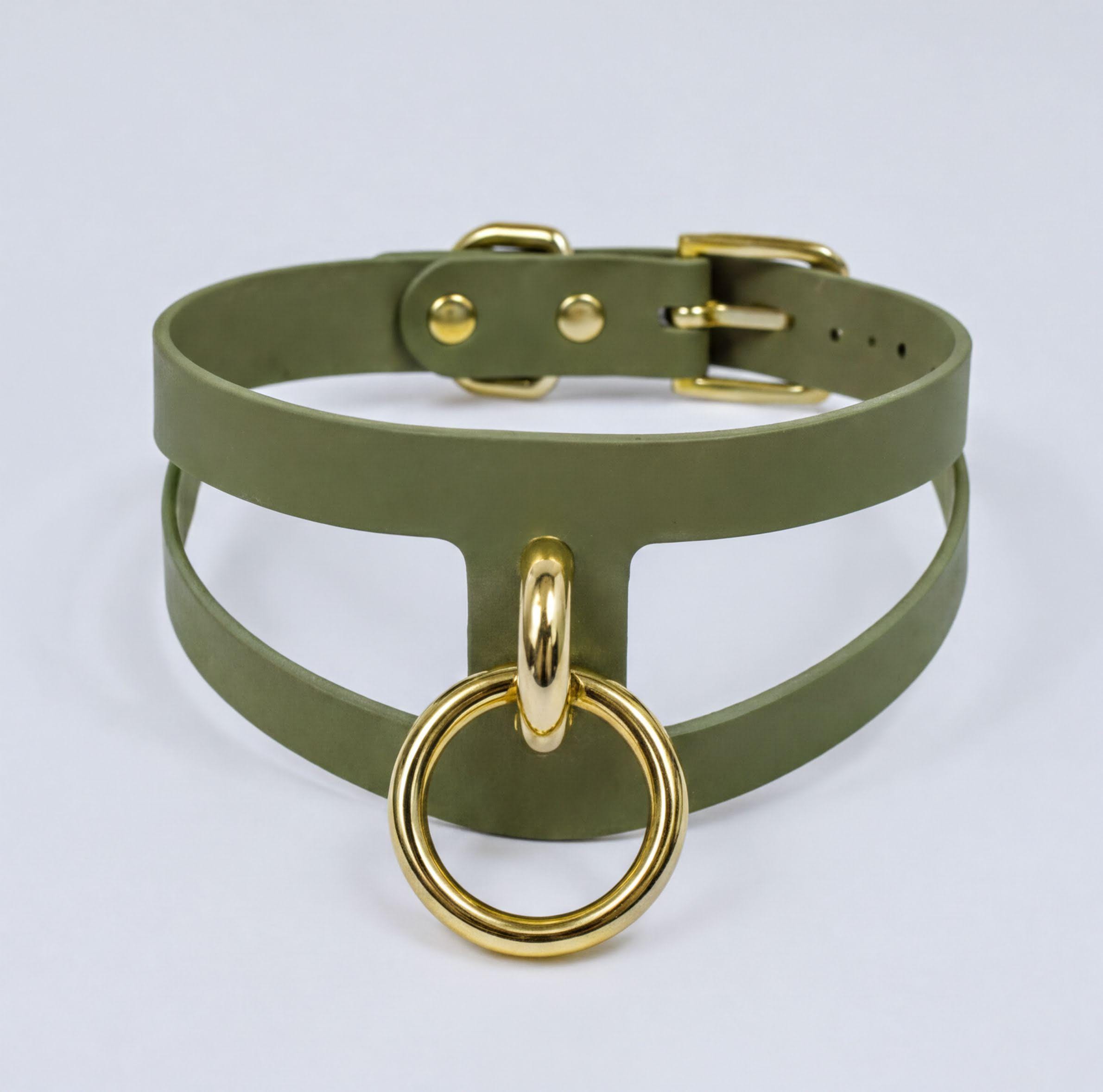 A green choker necklace with a gold-colored metal ring attached to it.
