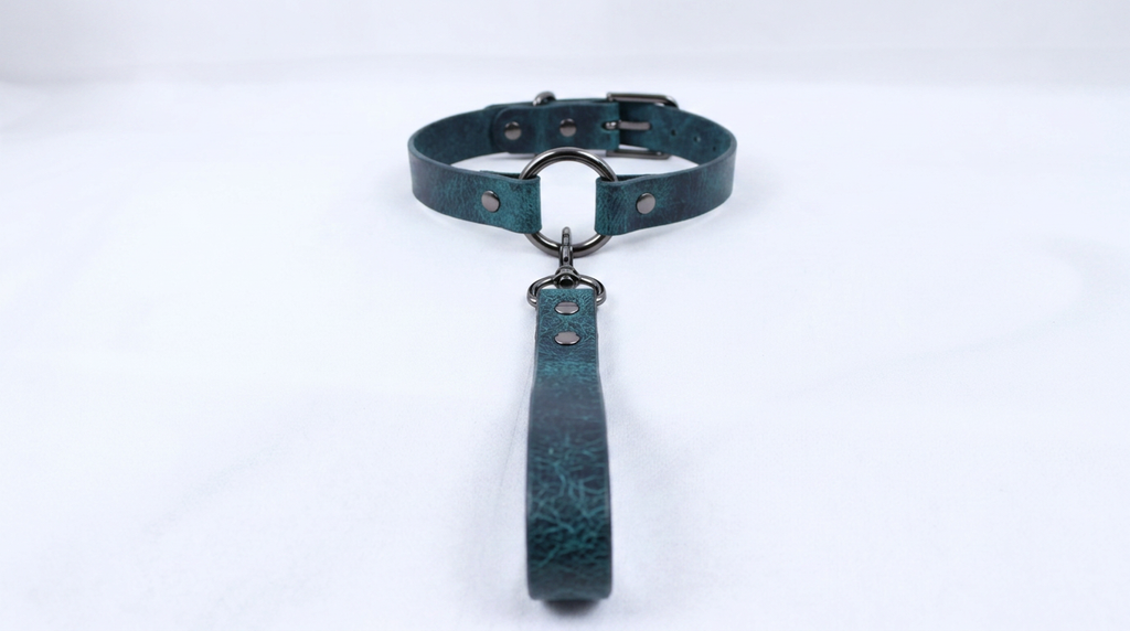 A dark green leather collar with a metal buckle and a handle attached to it.