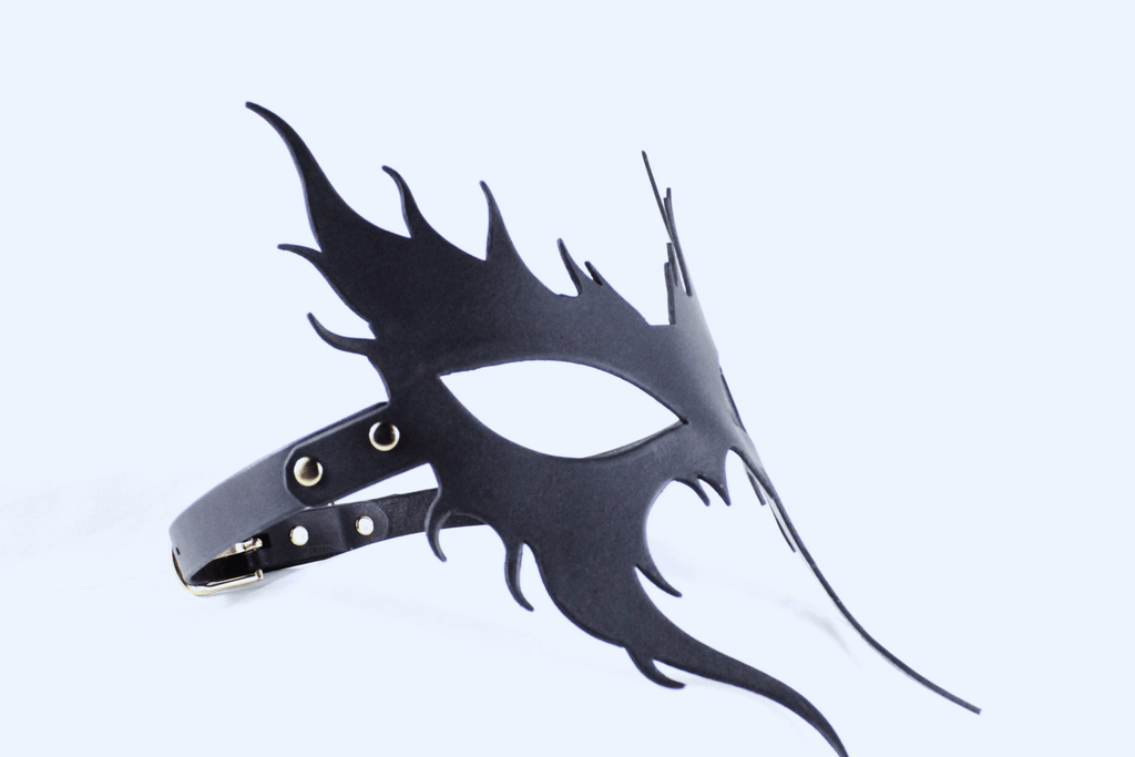 A black mask with a unique, stylized design is shown against a white background.