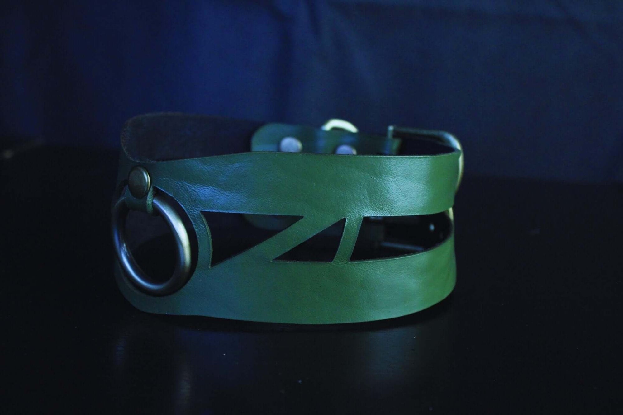 Geometric green leather choker collar with artistic cut-outs and O-ring, perfect for bondage and submissive jewelry.