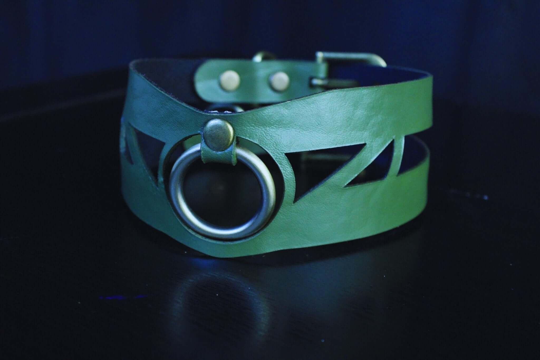 Geometric green leather choker collar with O-ring, perfect for BDSM, submissive jewelry, and edgy fashion aesthetics.
