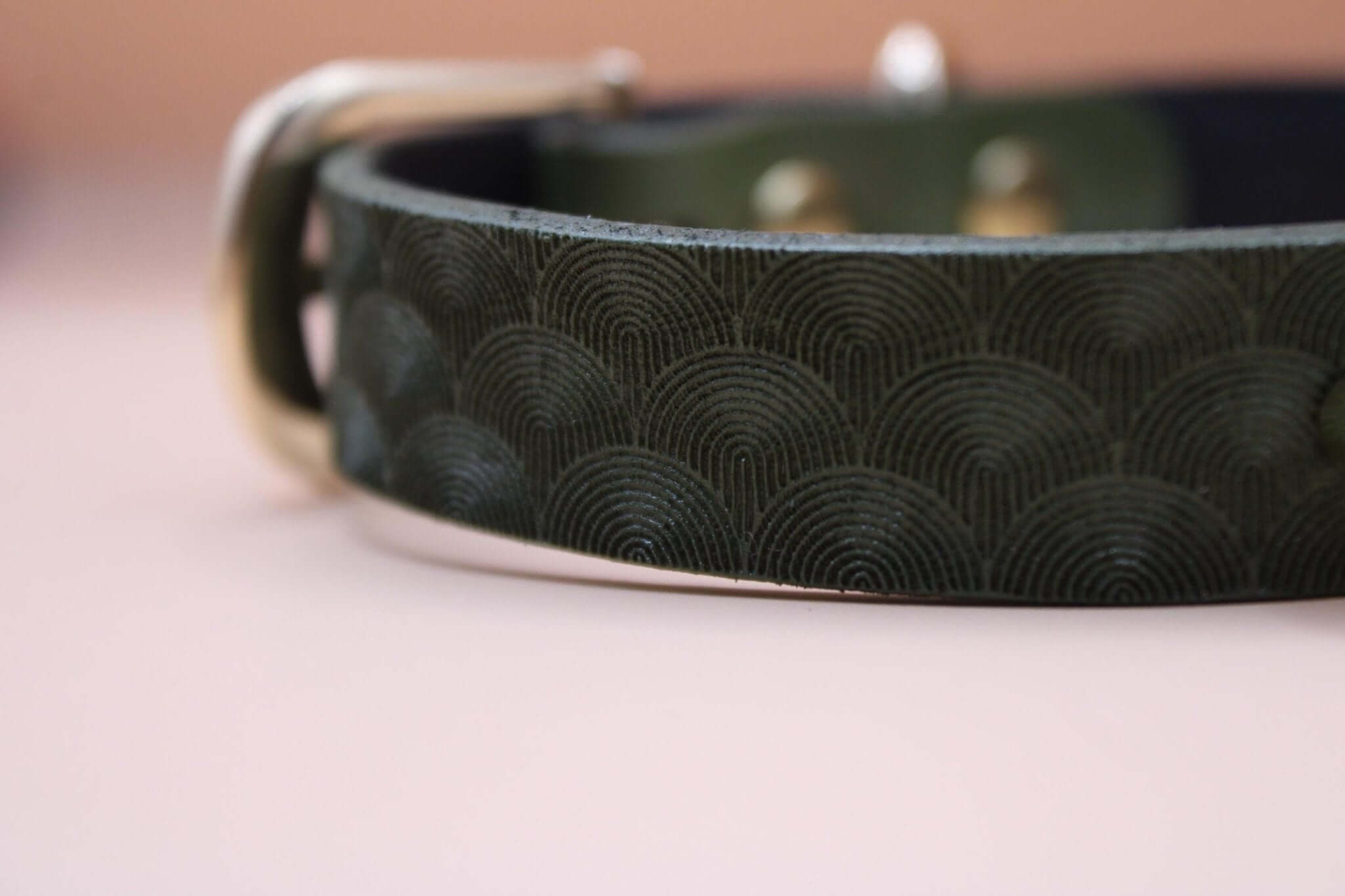 Elegant green leather submissive collar with intricate wave pattern, perfect for discreet day wear and BDSM aesthetics.