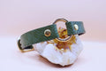 Green leather geometric O-ring submissive collar on crystal, ideal for BDSM fashion and play.