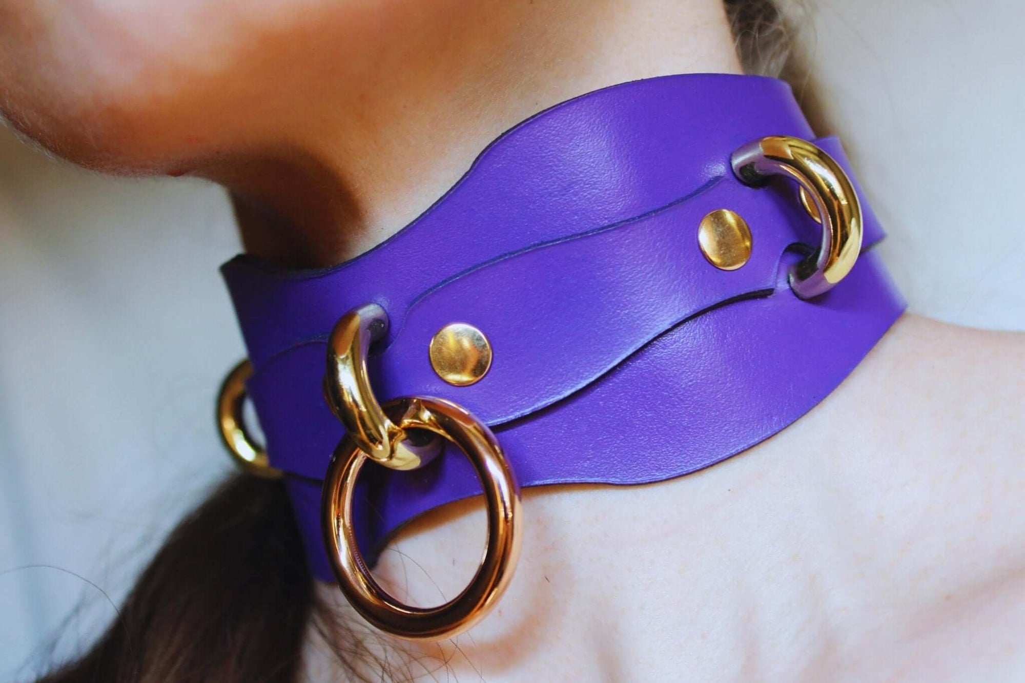Elegant purple leather submissive collar with gold rings, perfect for BDSM, bondage fashion, and unique accessories.