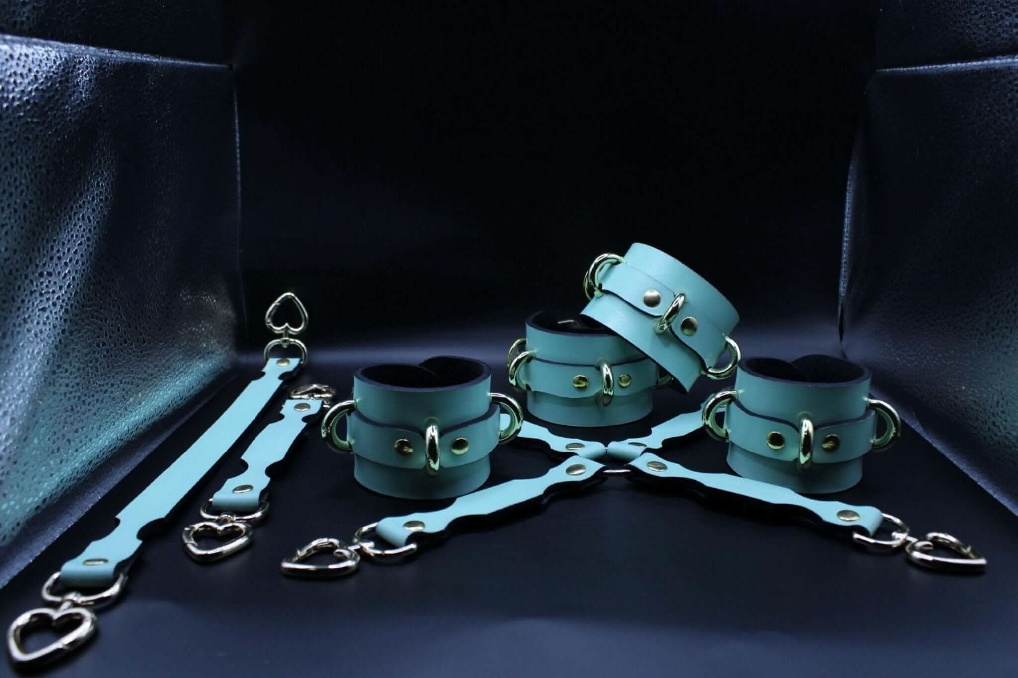 Handmade leather cuffs in turquoise for BDSM play, featuring heart connectors, perfect as sub collar or bondage gear.