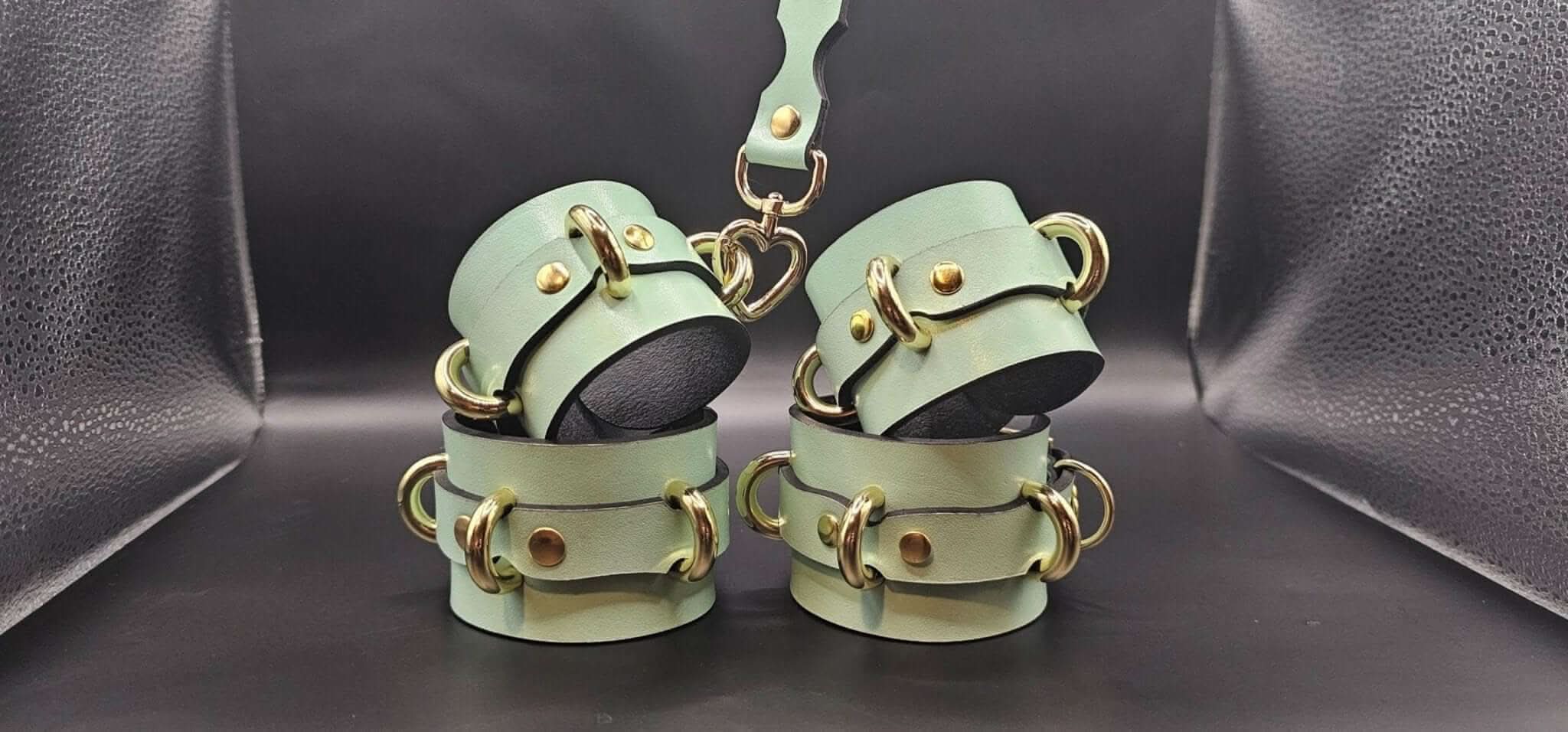 Handmade leather cuffs for BDSM play, adjustable wrist or ankle restraints with connector, premium bondage gear.