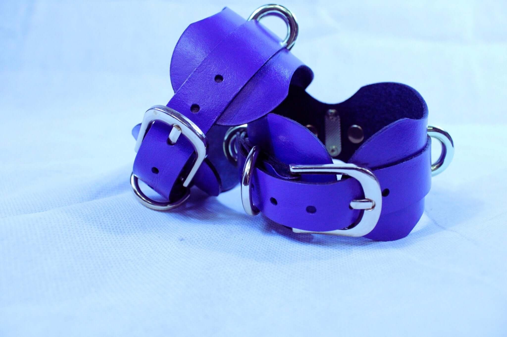 Handmade purple leather wrist cuffs with metal buckles, perfect for BDSM, bondage gear, and sub collar accessories.